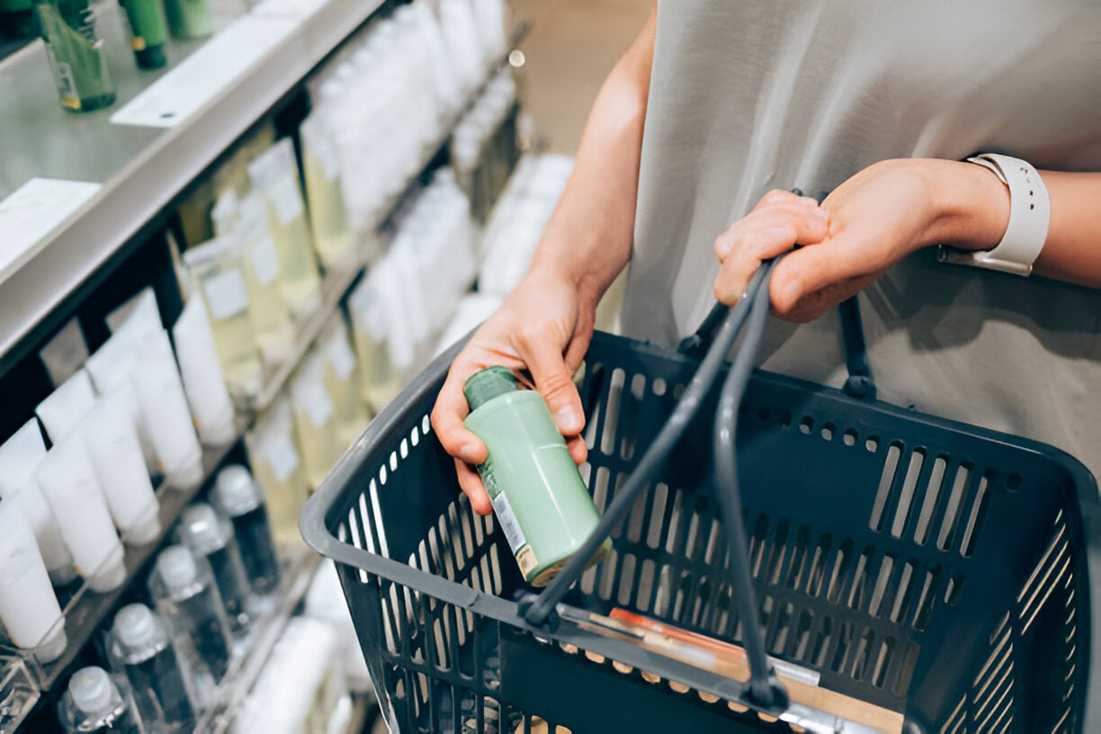 Mujer comprando champú en un supermercado.