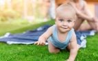 Una foto de un bebé que está gateando en un jardín.