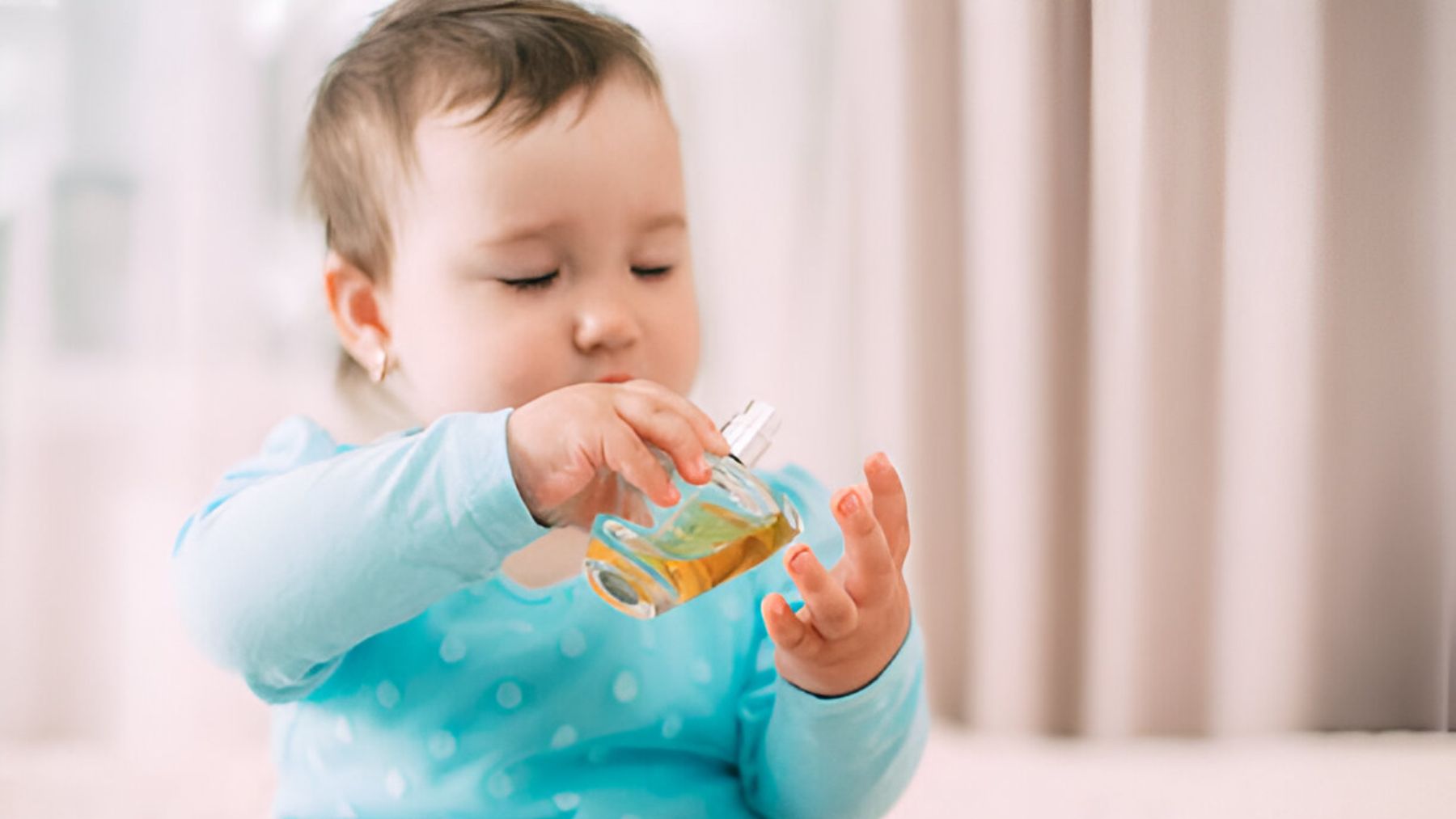 Bebé con botella de perfume.