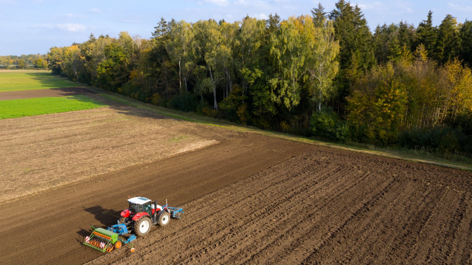 Un agricultor trabajando en sus tierras con un tractor.