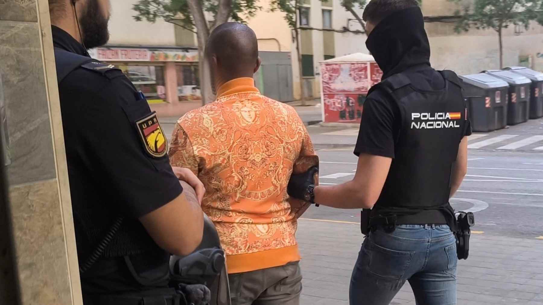 El detenido, conducido por dos agentes de la Policía Nacional.