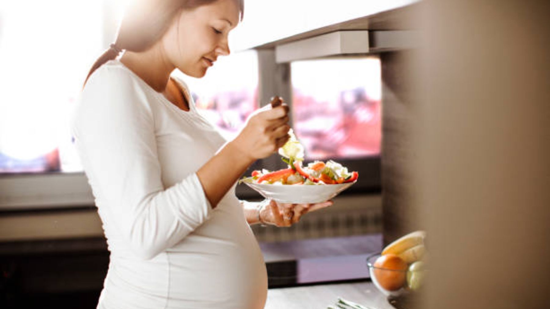 Mujer embarazada comiendo.