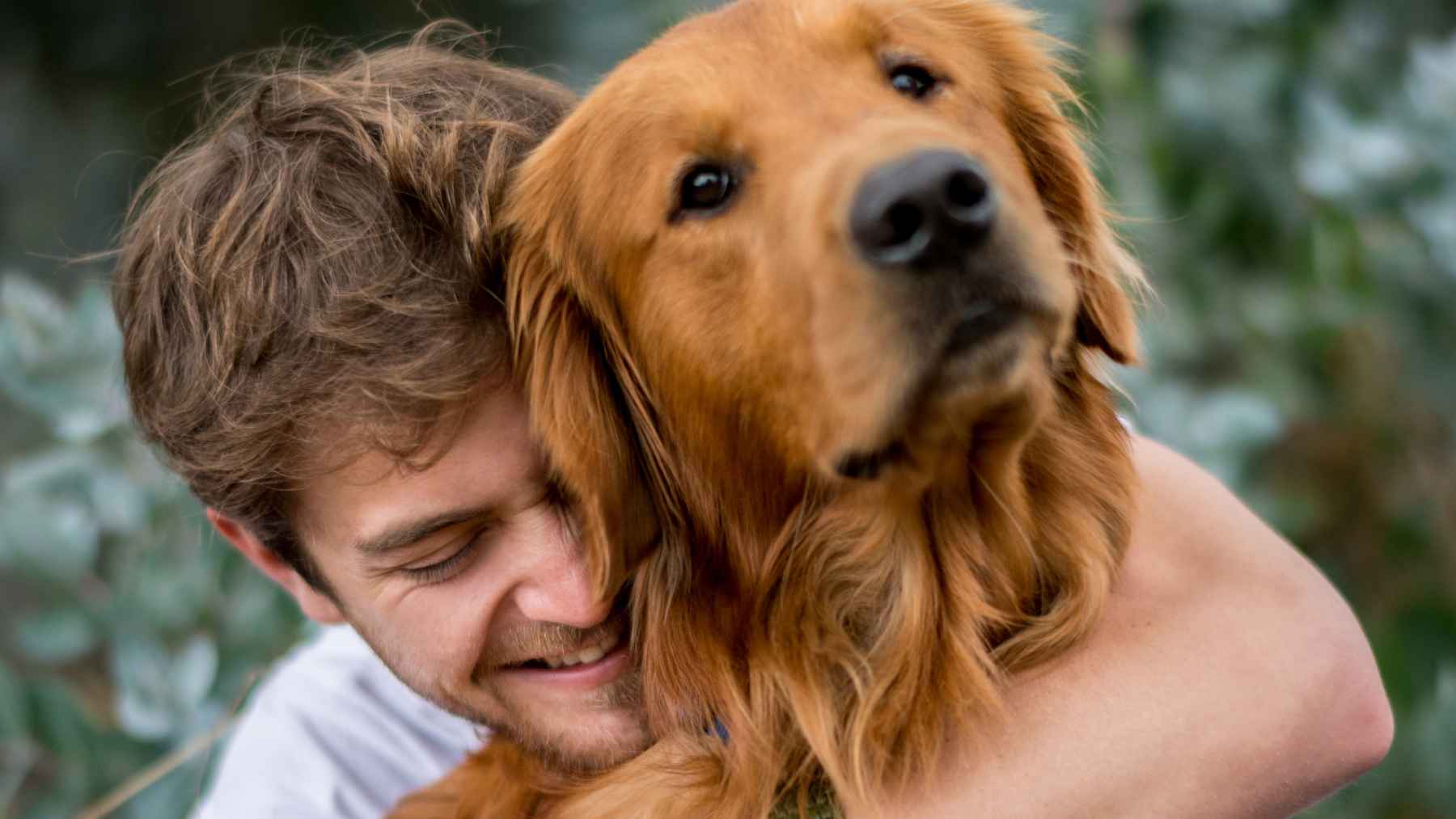 Un joven abrazado a su perro.