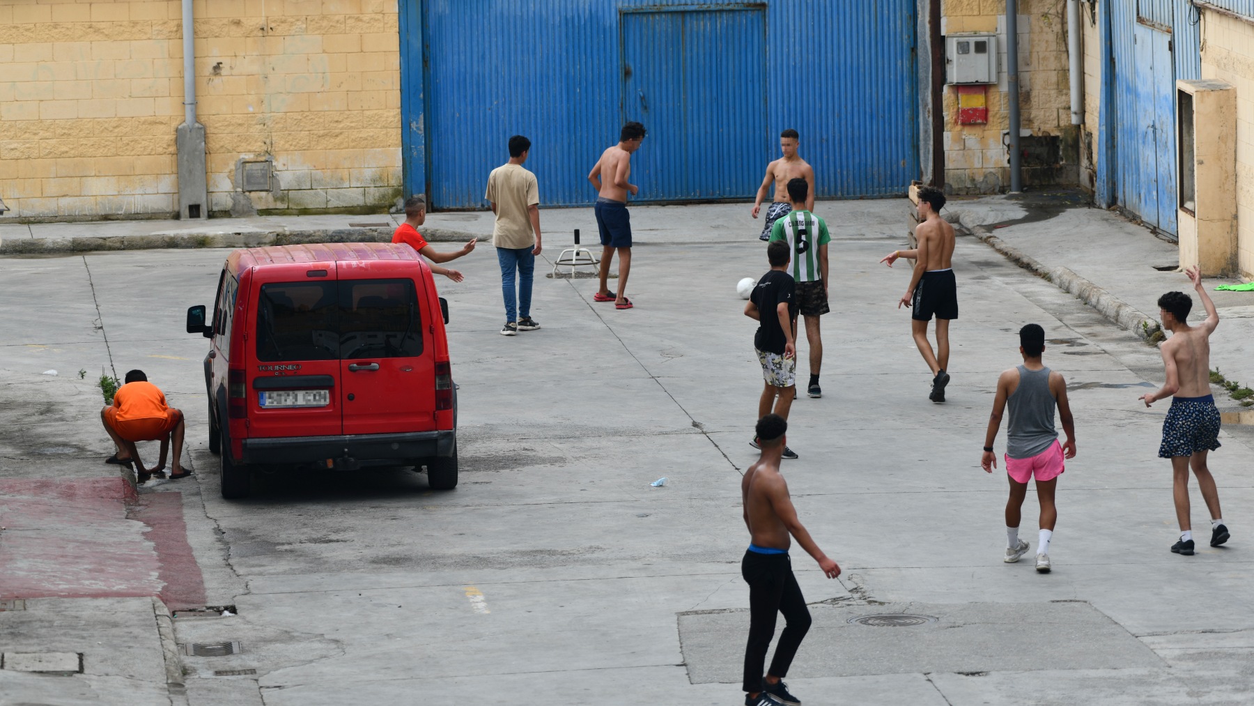 Varios menores inmigrantes juegan al fútbol en las naves de El Tarajal, en Ceuta. (Foto: EP)