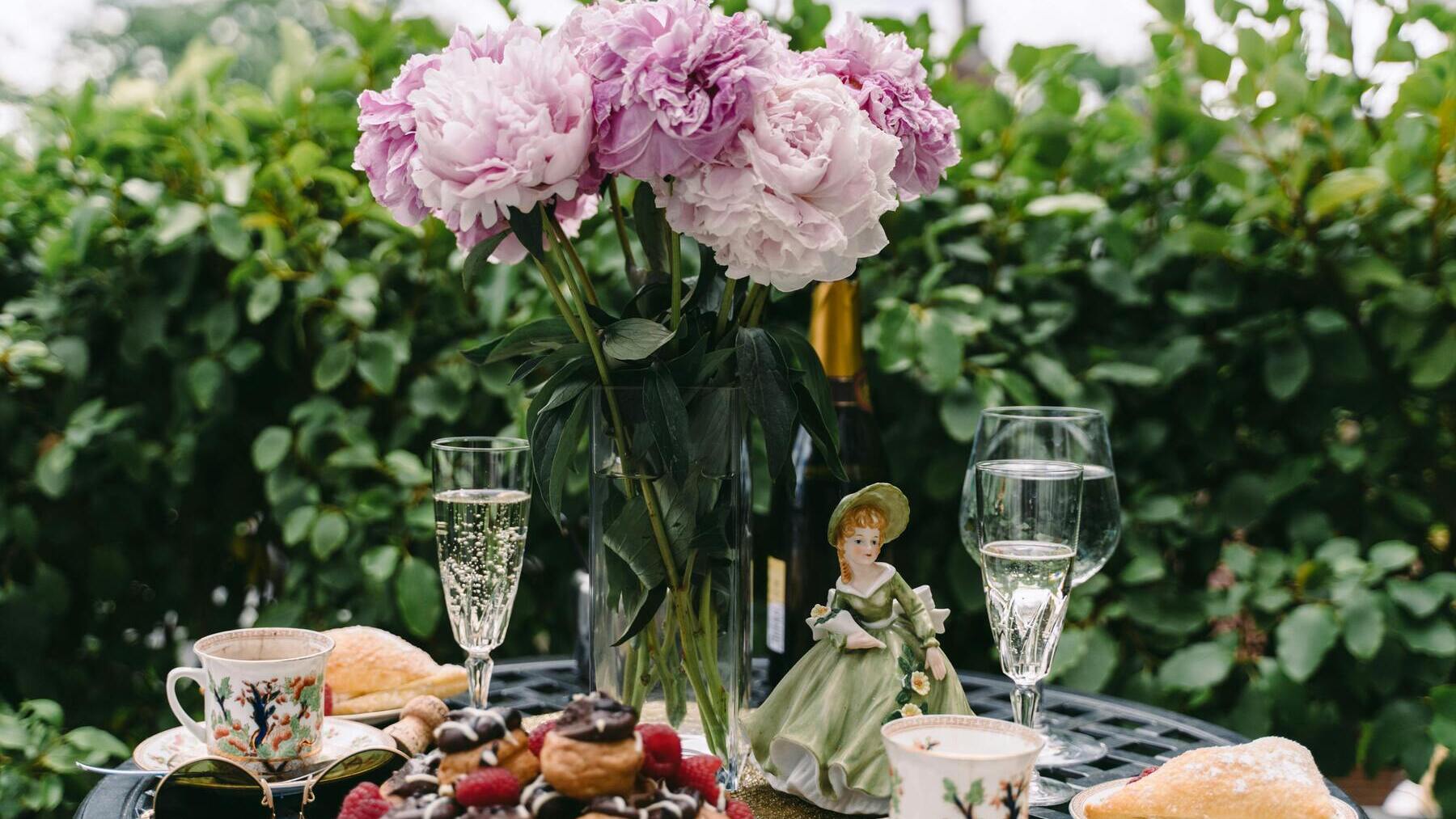 Mesa preparada para comer en un jardín.