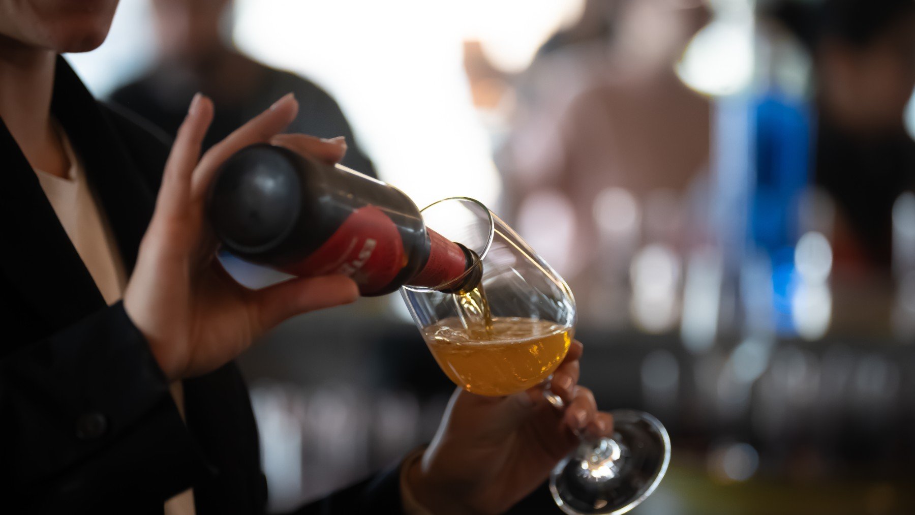 Una mujer se sirve una cerveza en un vaso. (EP)