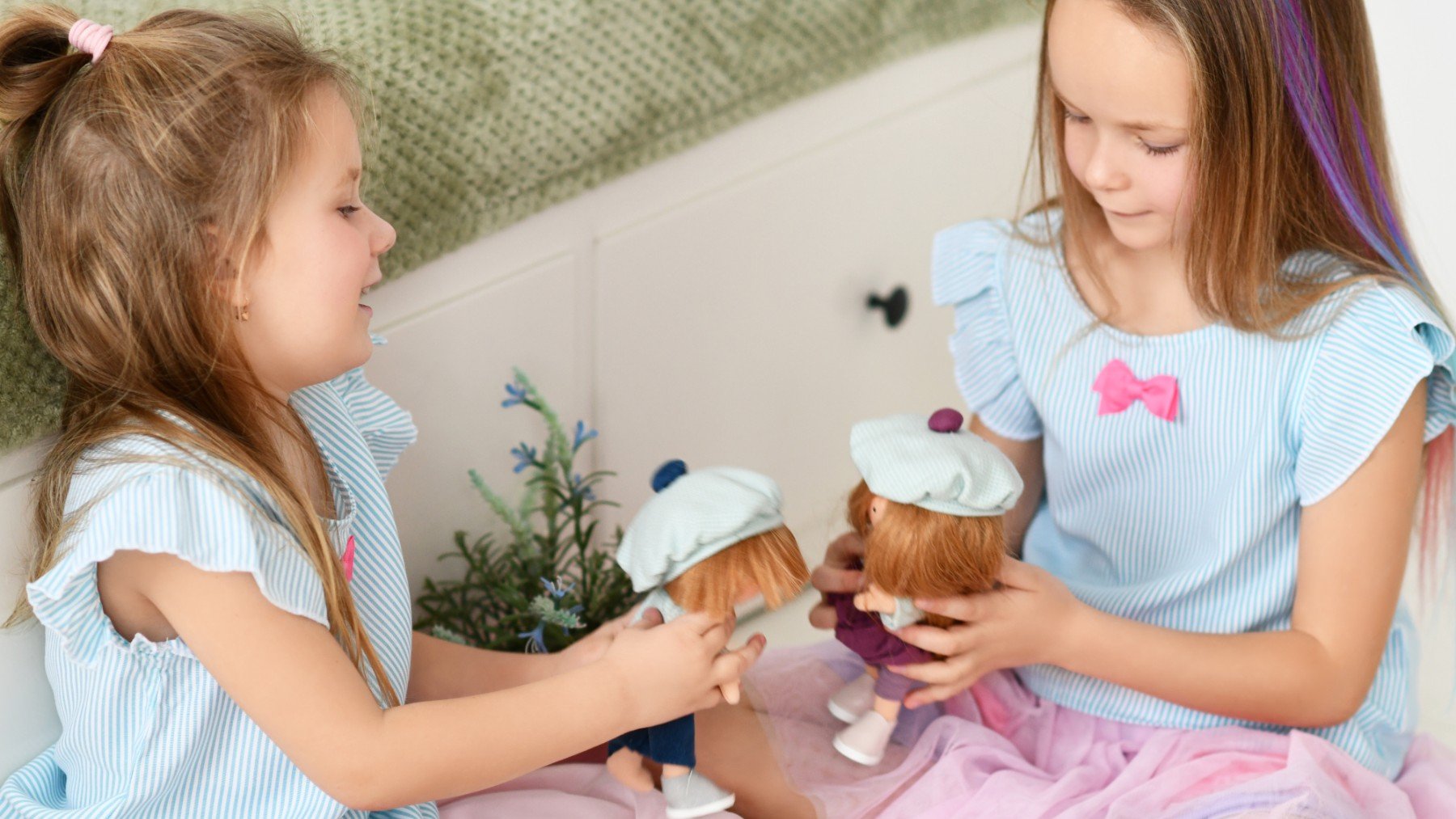 Dos niñas hablando con sus muñecos.