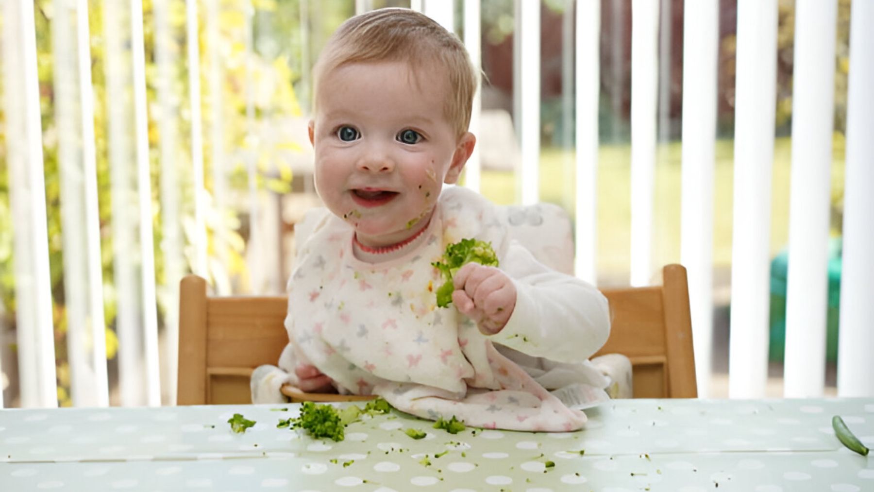 Bebé comiendo brócoli.