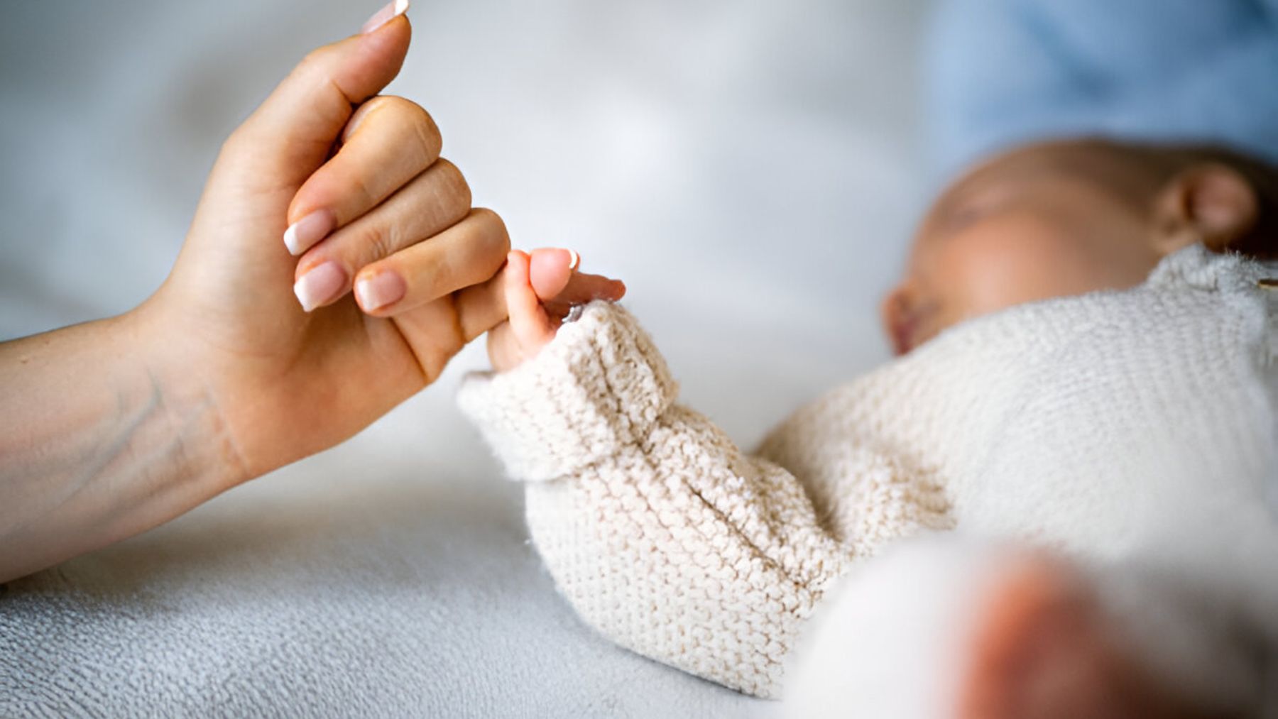 Bebé cogiendo mano de su madre.