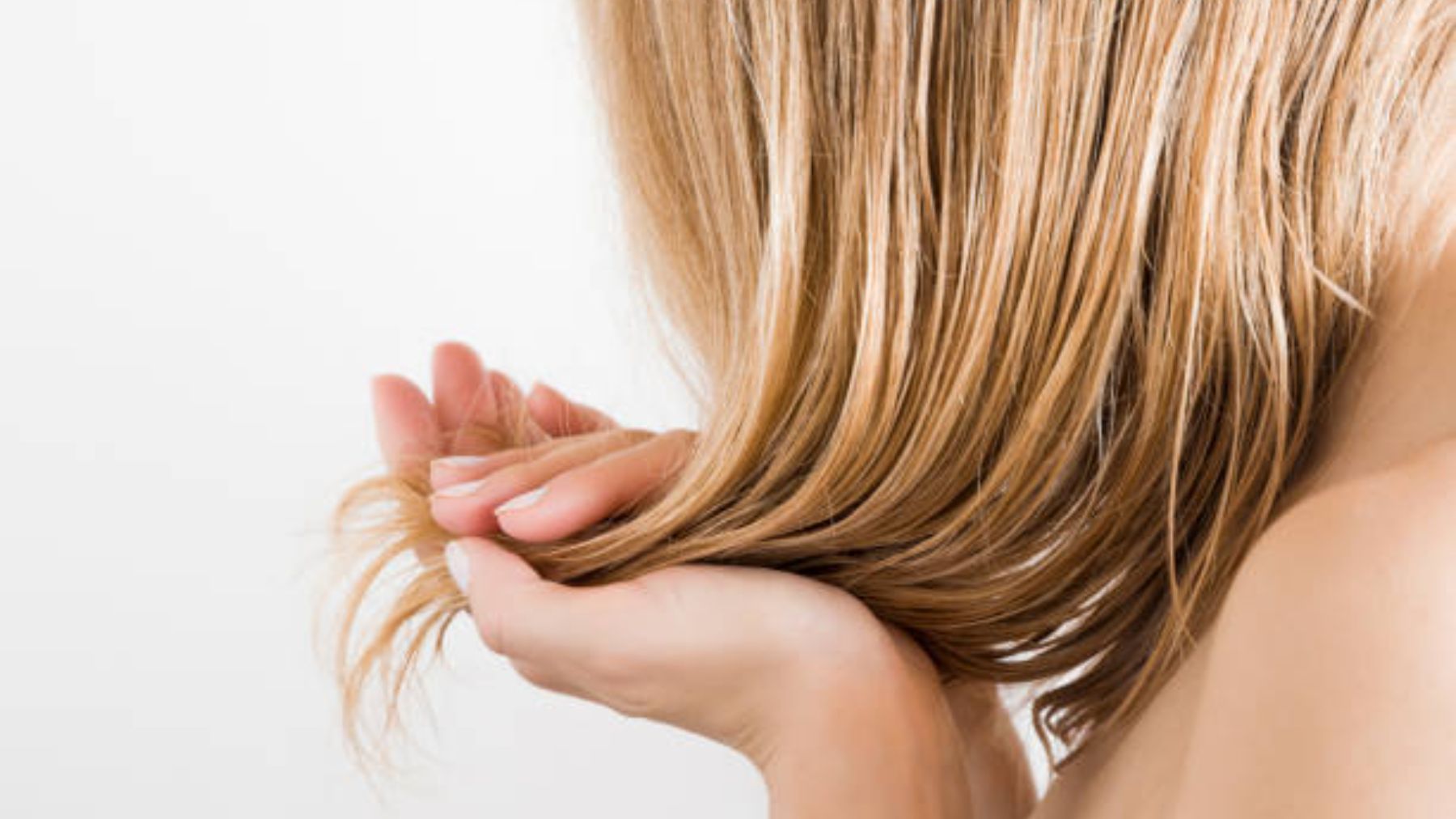 Mujer aplicando producto en el pelo.