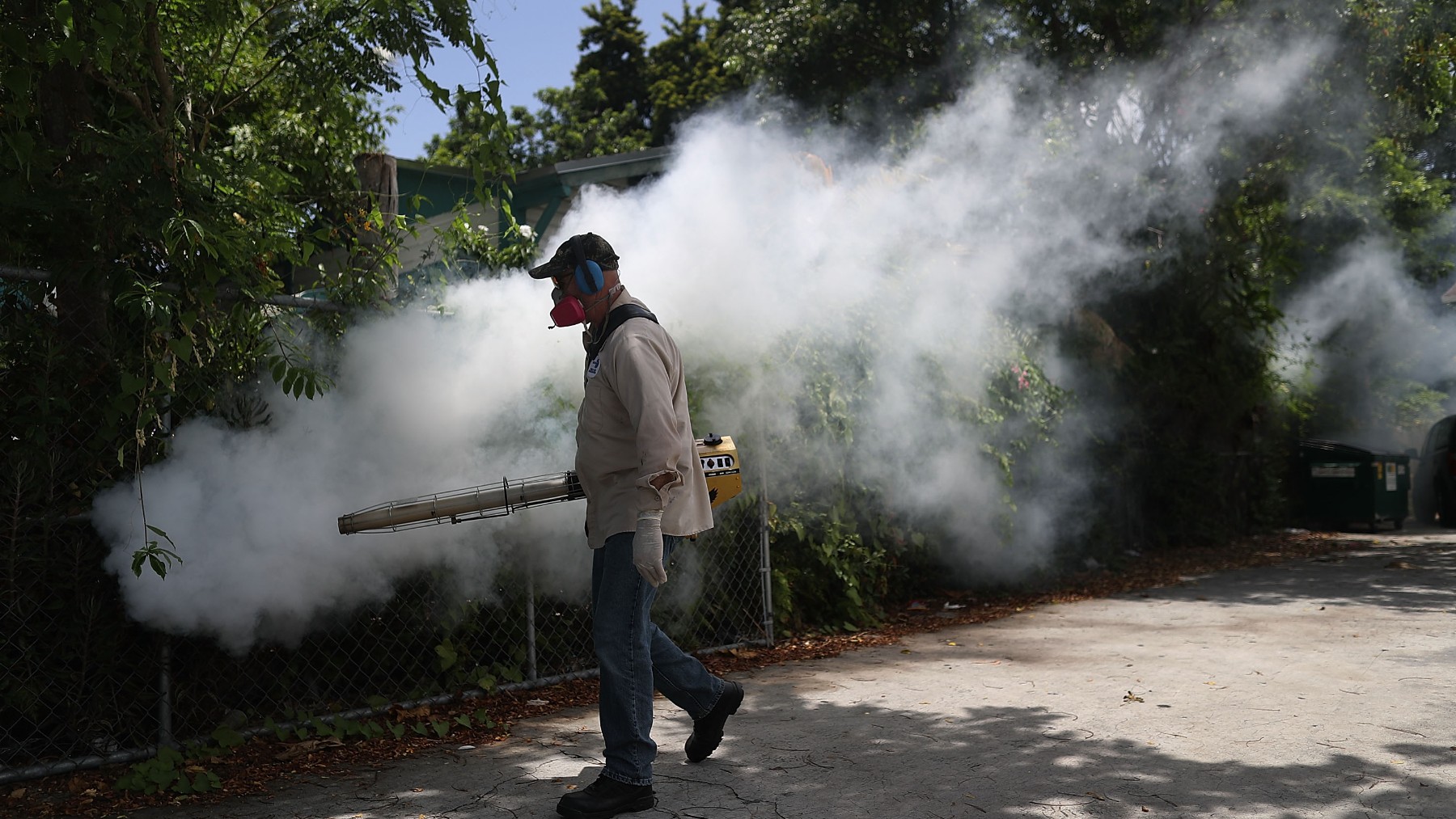 Un operario fumigando una zona residencial.