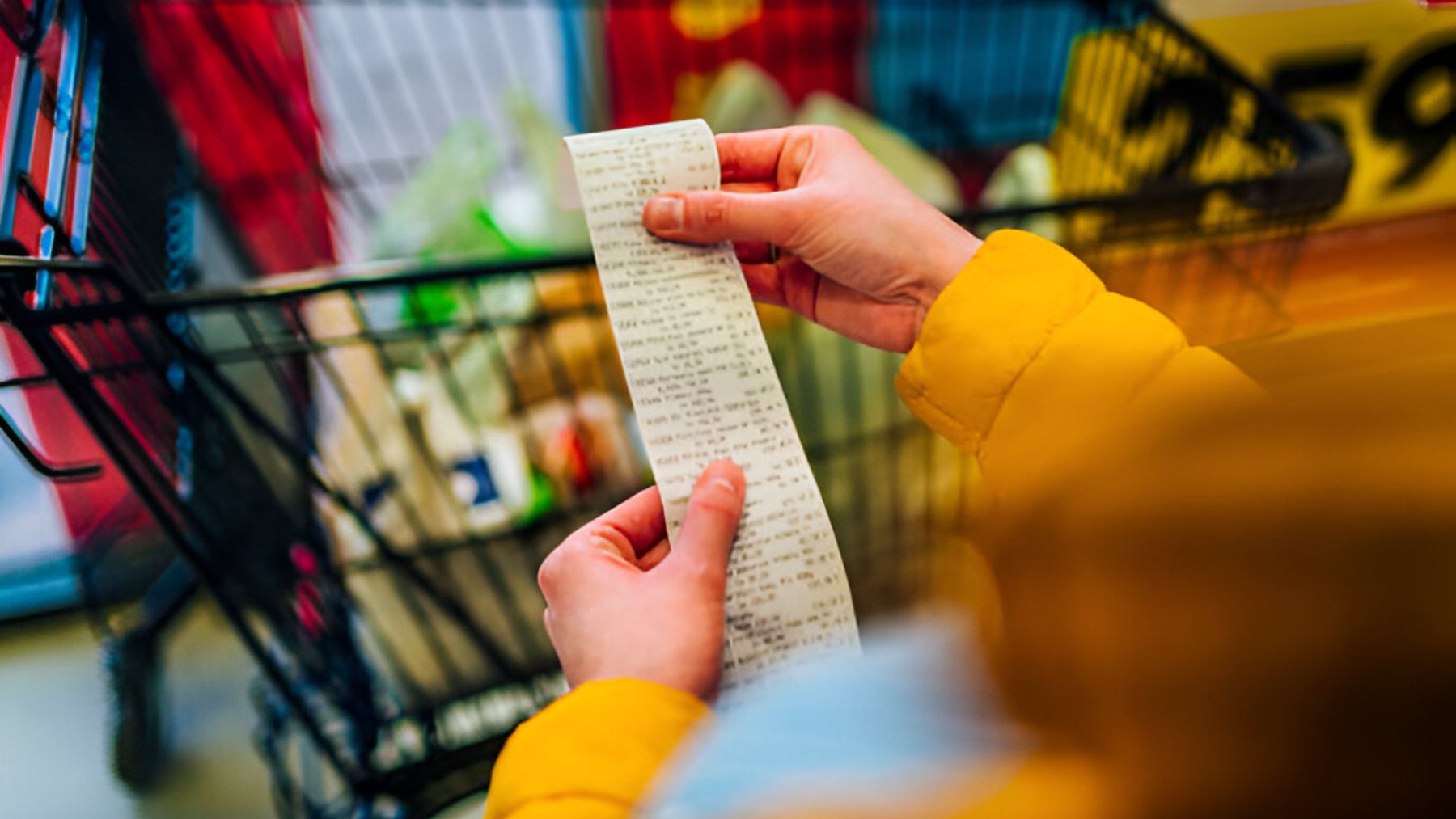 Mujer revisando ticket de compra del supermercado.