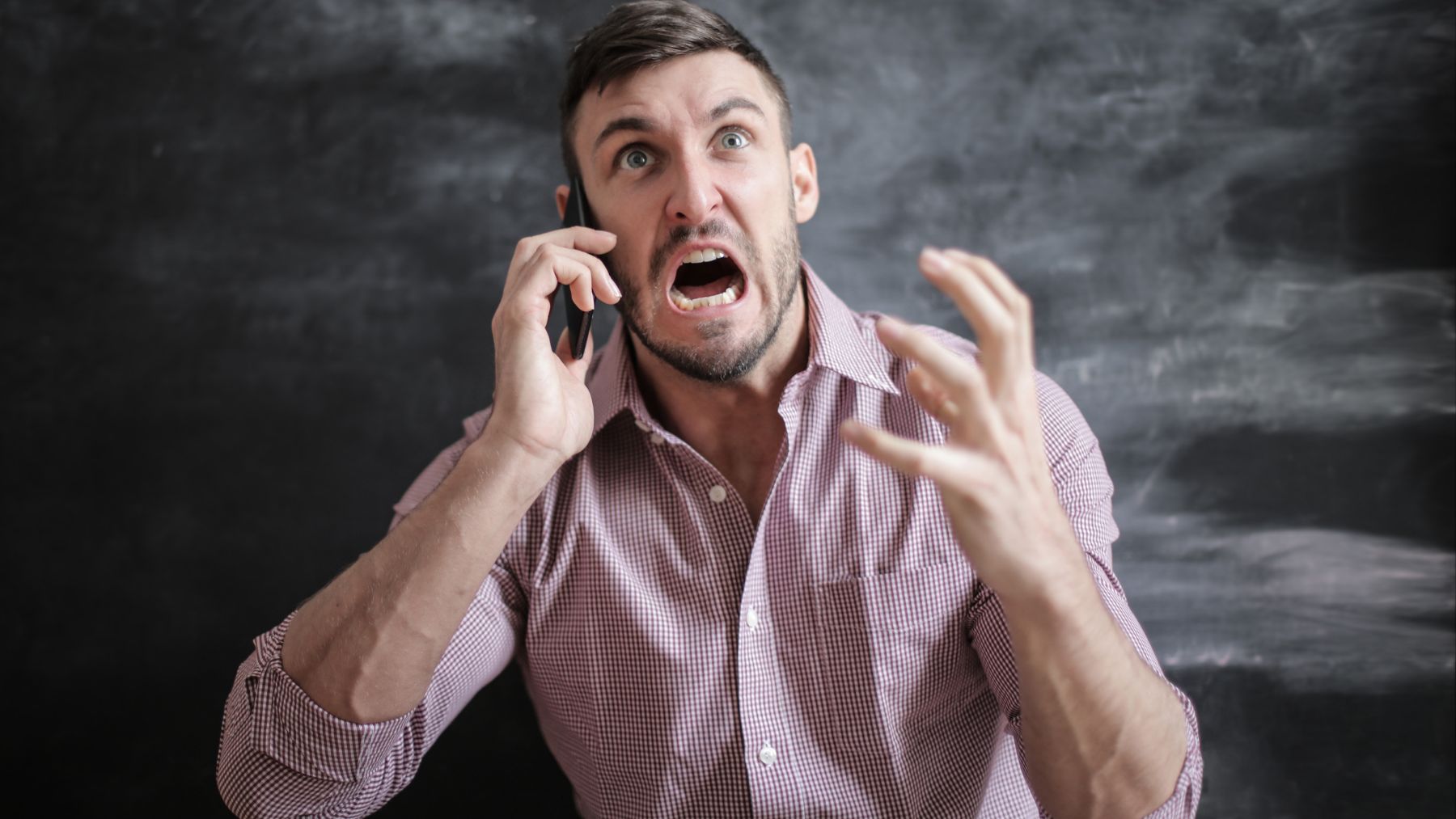 Un hombre enfadado hablando por teléfono.