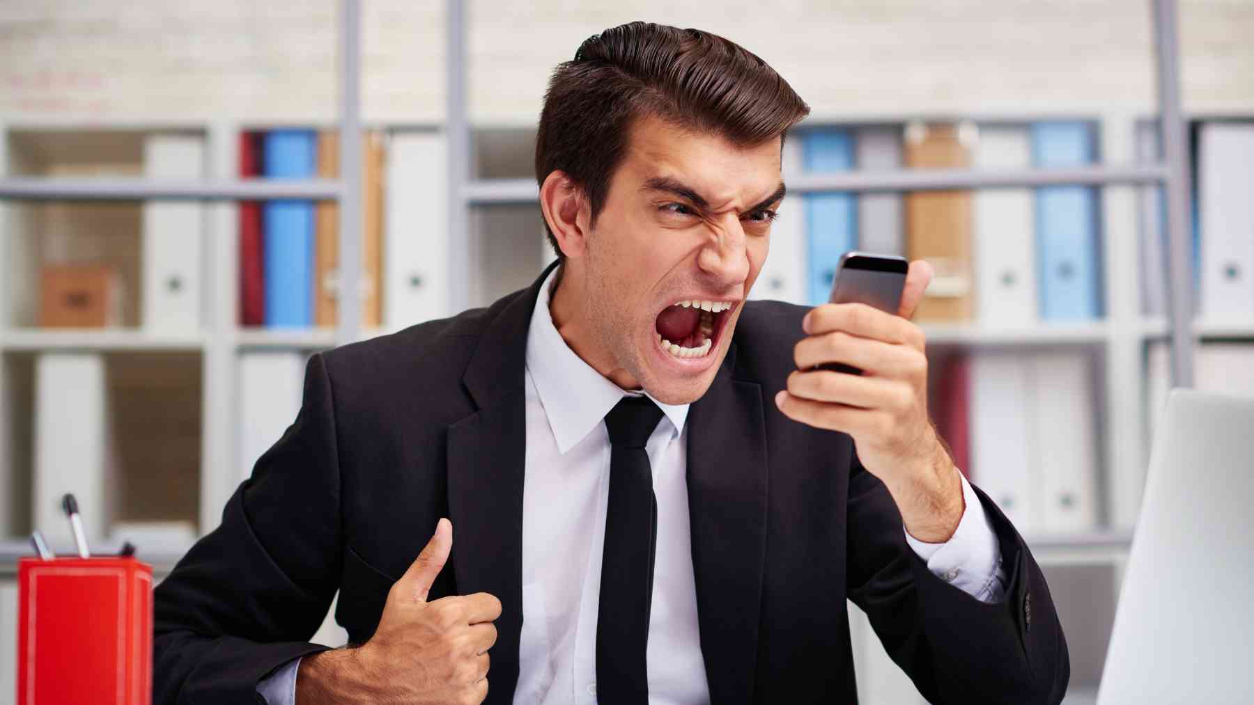 Un hombre enfadado hablando por teléfono.