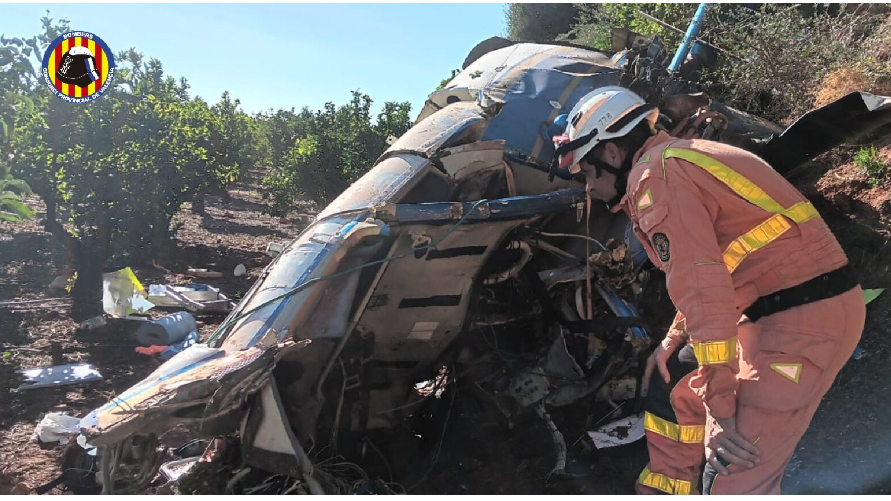 Un bombero junto al helicóptero siniestrado en Valencia.