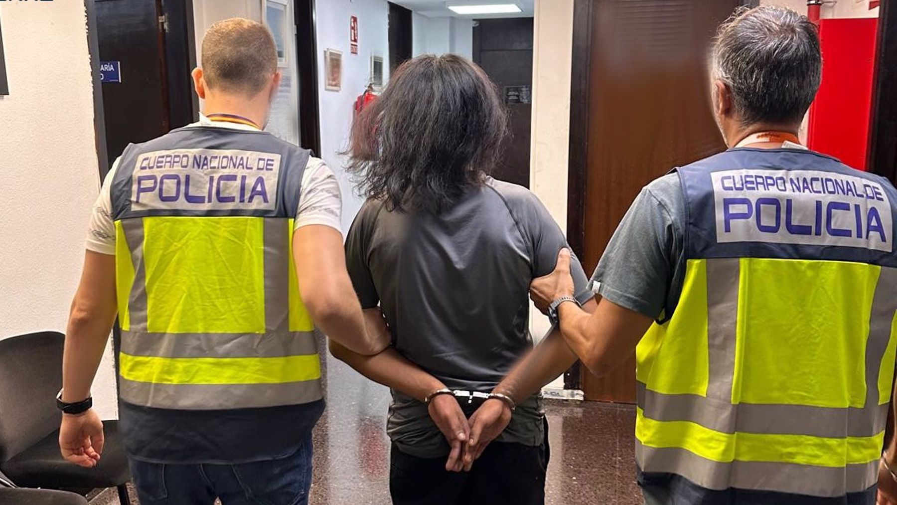 El detenido, conducido por dos agentes(1)