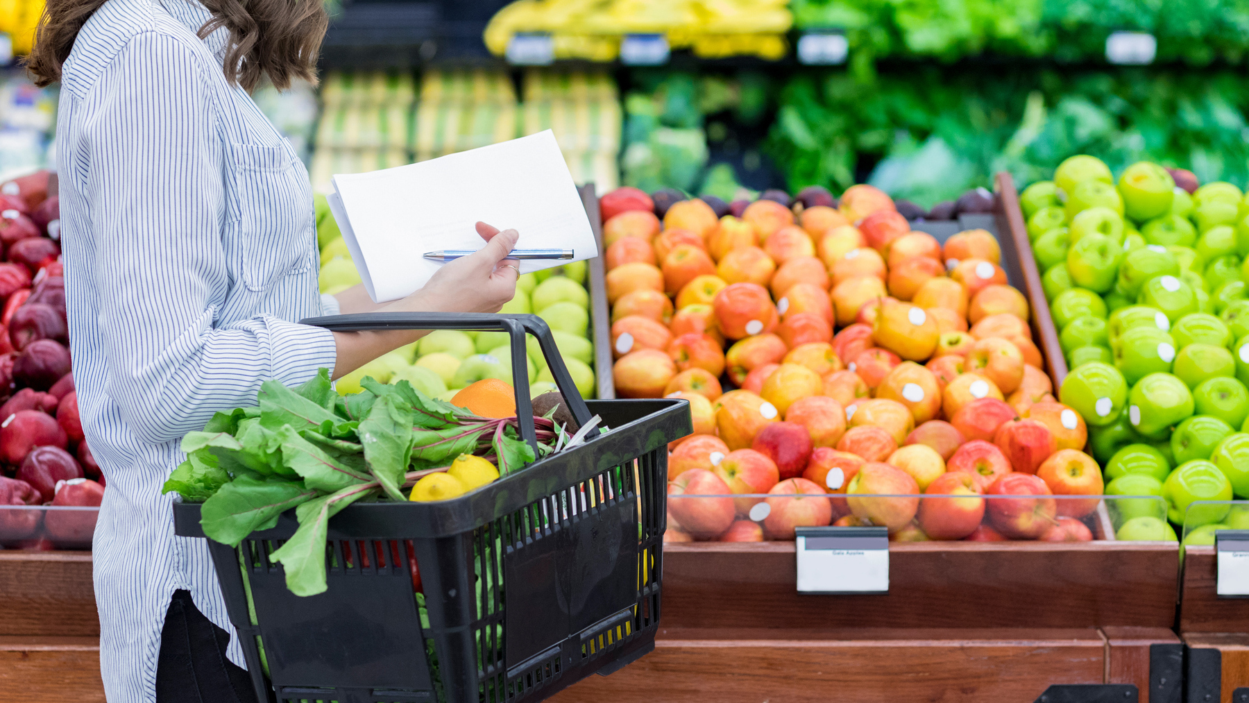 Unrecognizable woman shops for produce in supermarket