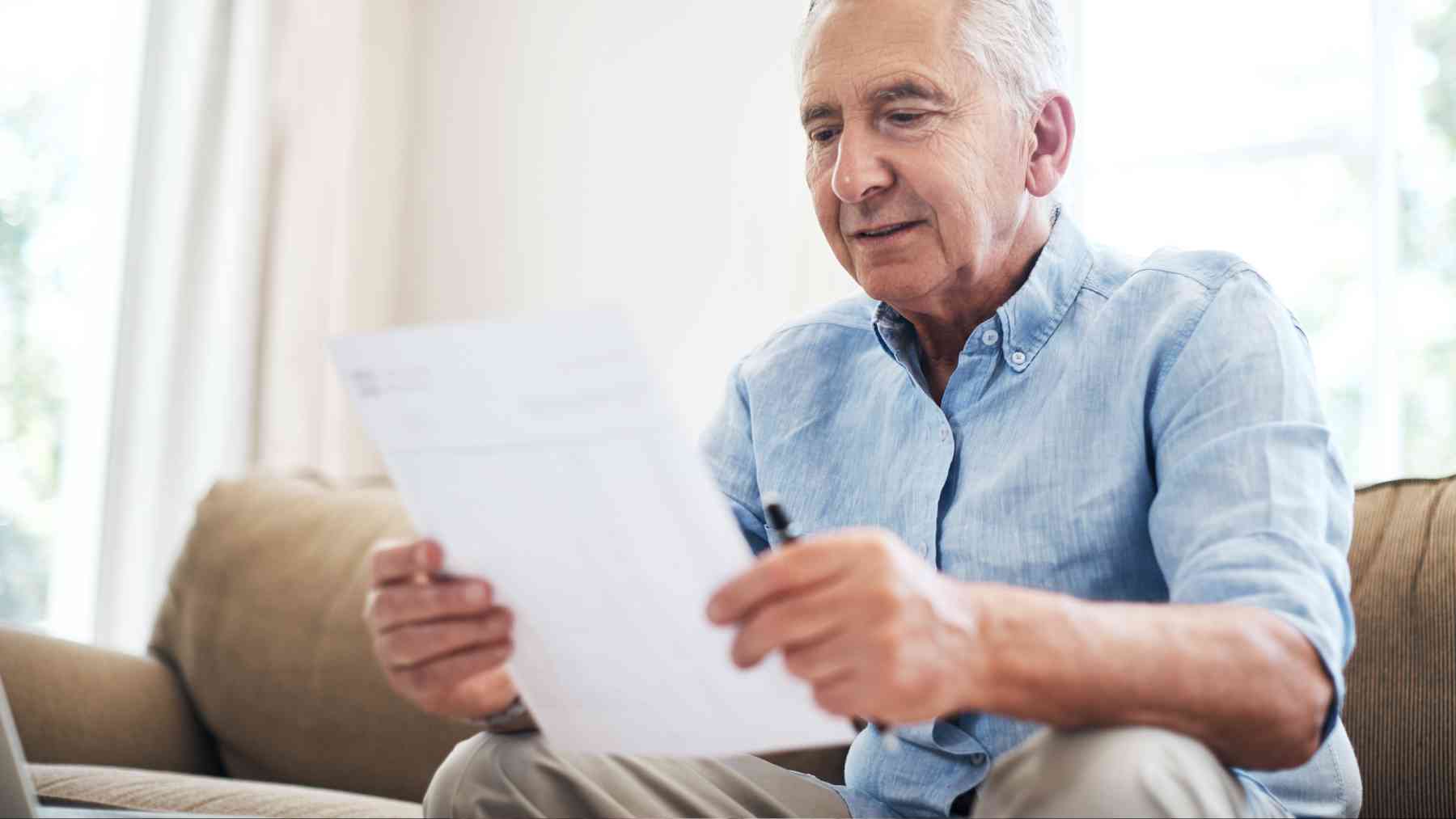 Un señor consultando unos documentos.