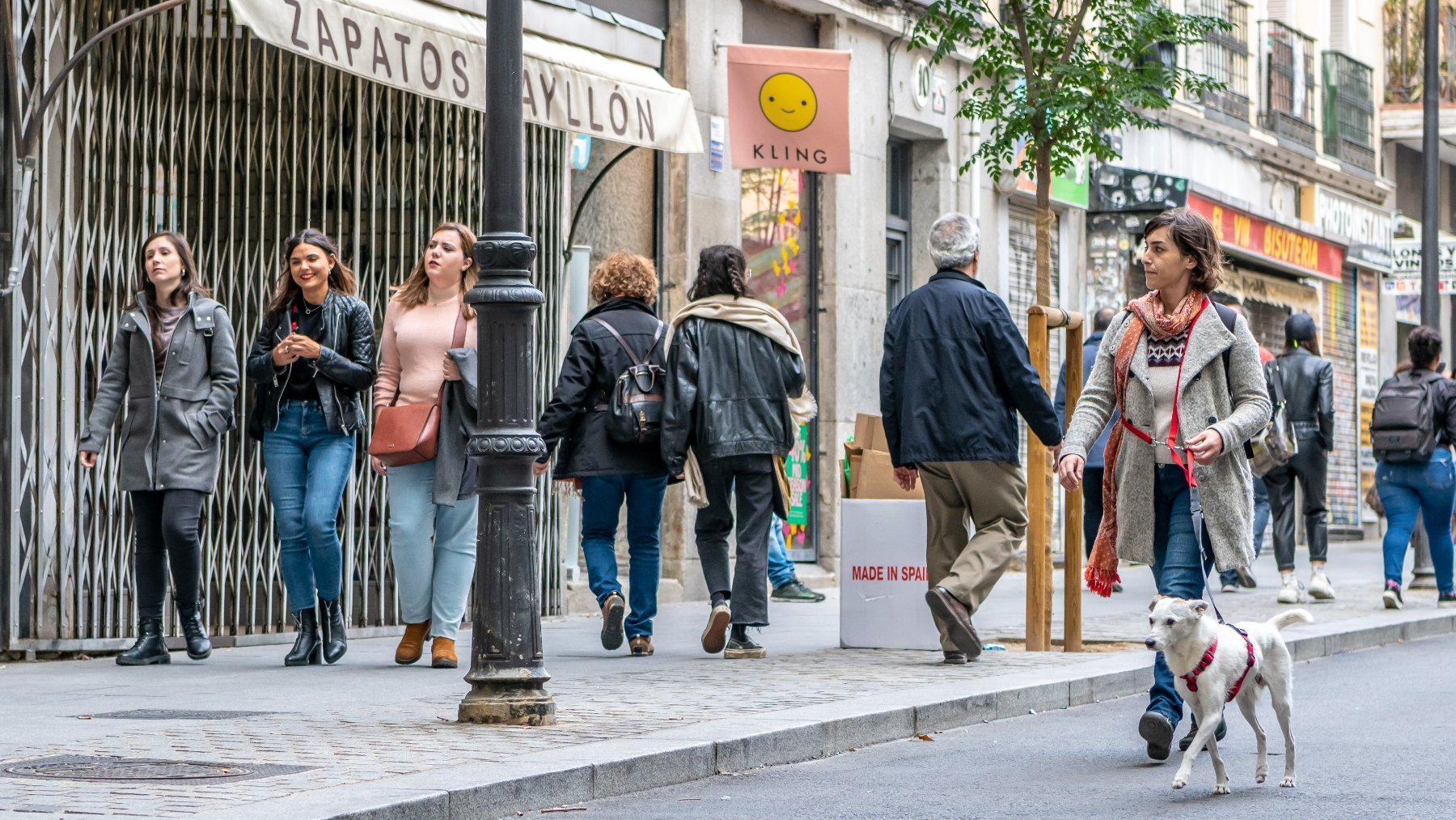 Una dueña pasea su perro por el barrio de Malasaña en Madrid