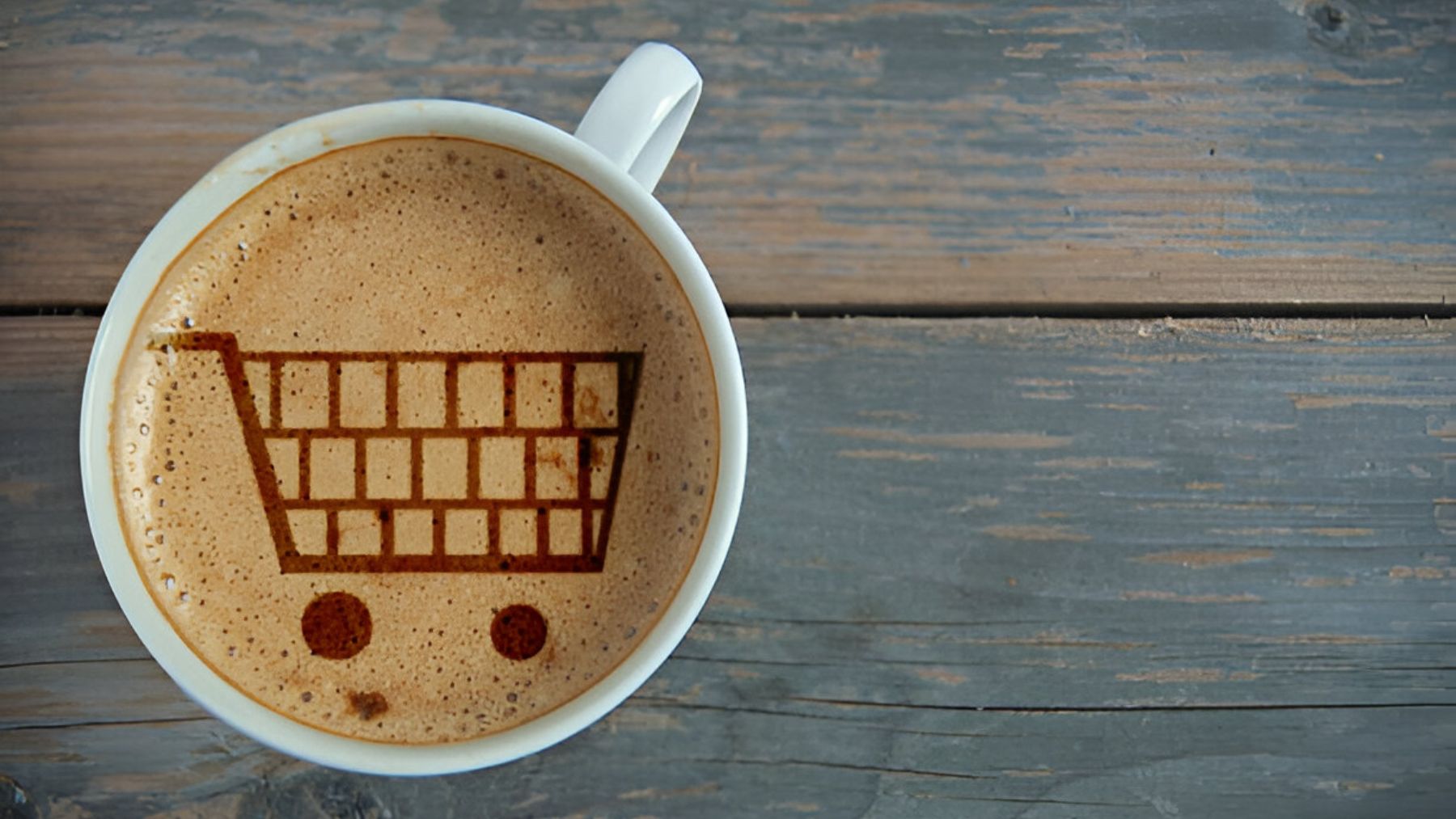 Taza de café con carrito dibujado en la espuma.