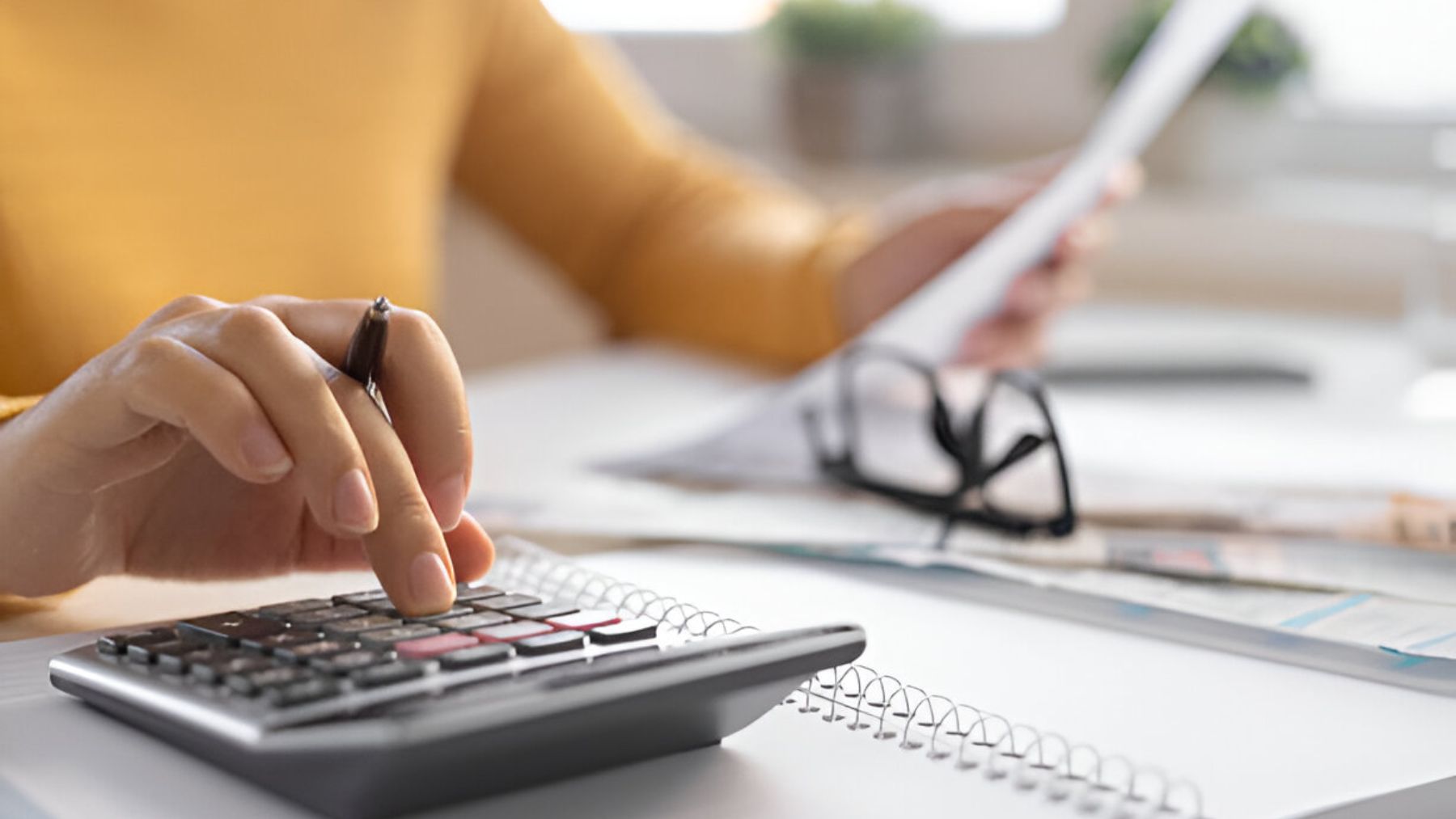 Mujer con calculadora mira su factura.