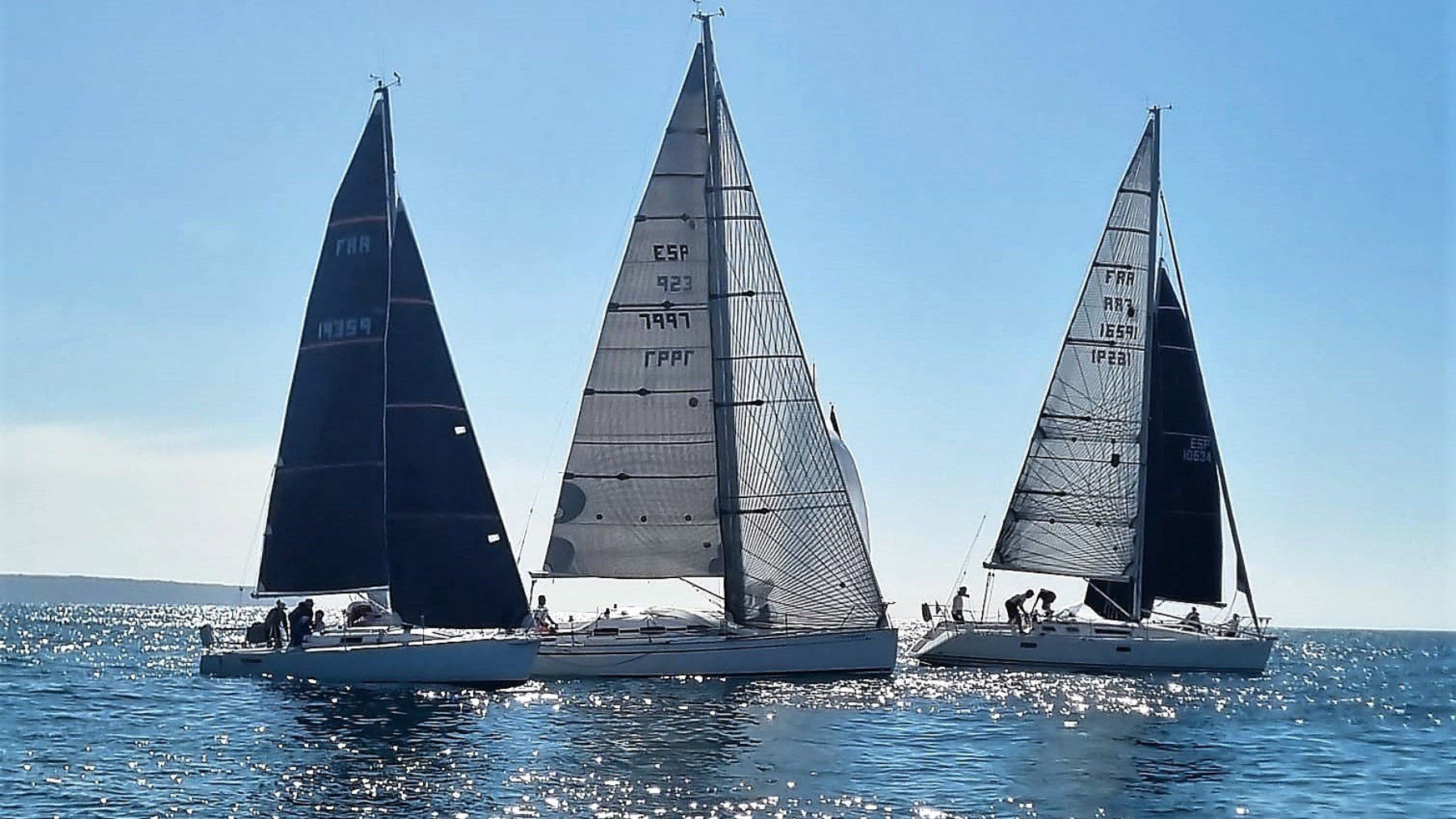 Tres embarcaciones en plena regata.