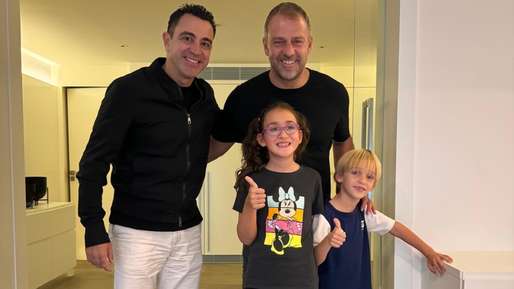 Xavi Hernández junto a Hansi Flick y dos niños.