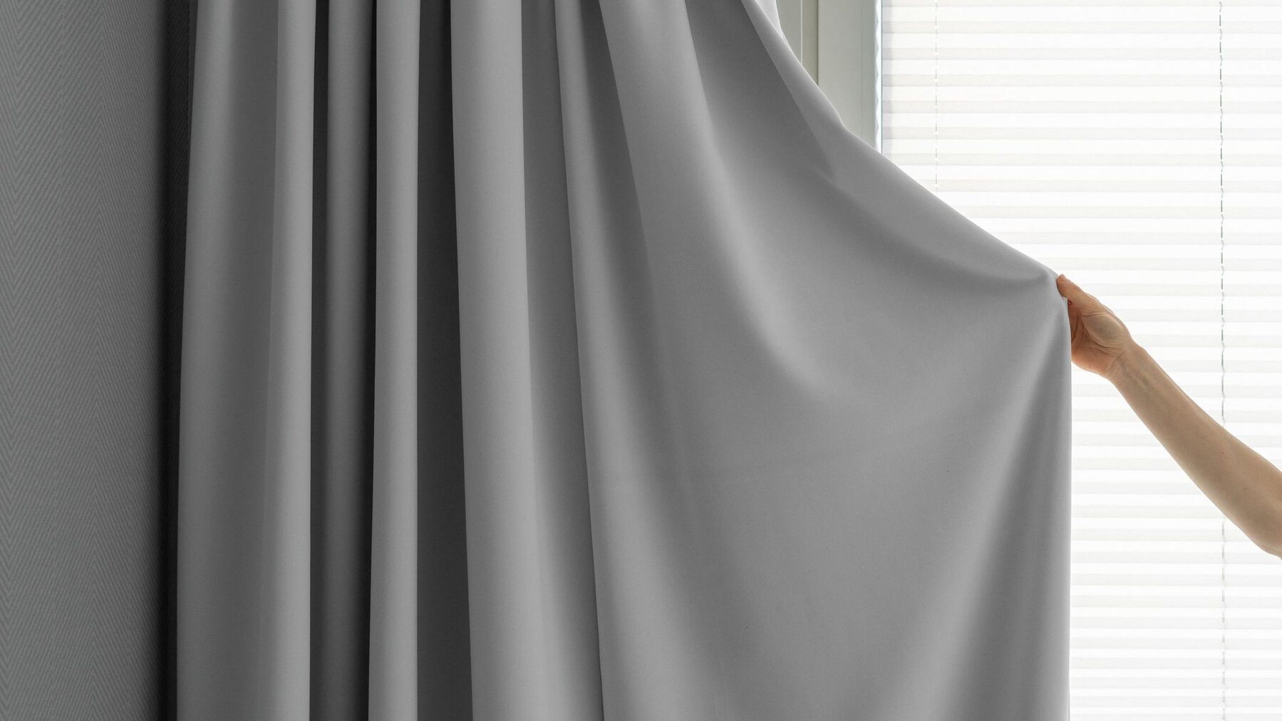 woman hand close curtain from daylight at bedroom