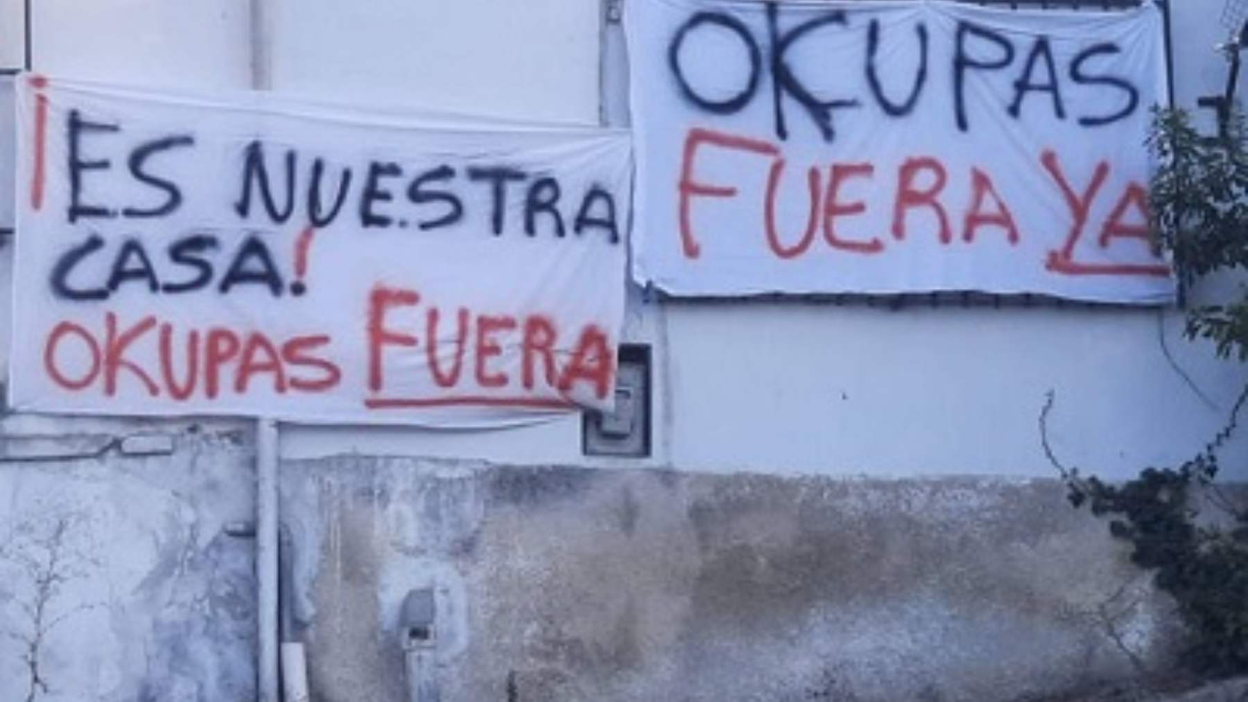 Pancartas contra los okupas en un edificio.