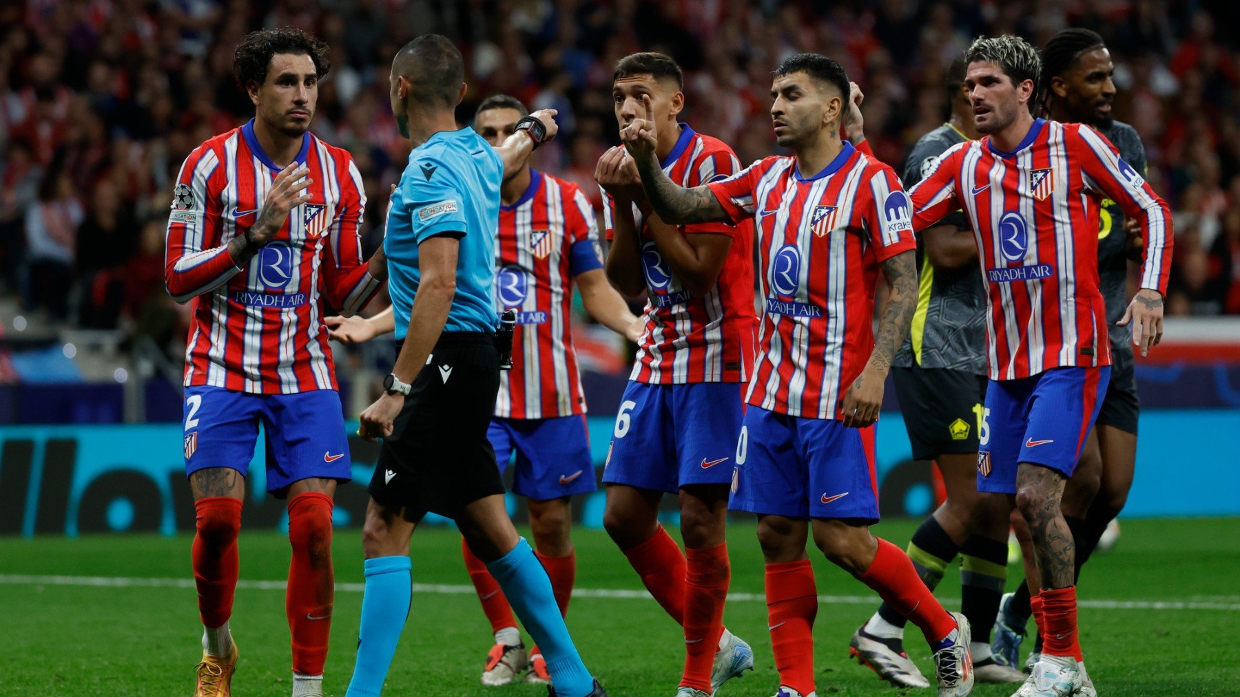 Los jugadores del Atlético recriminan a Guida el penalti señalado a favor del Lille. (EFE)