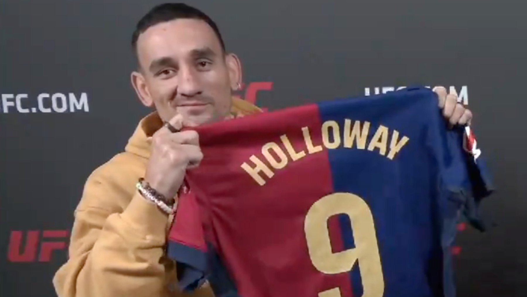 Max Holloway posa con una camiseta del Barcelona antes de su pelea contra Topuria. (Captura de pantalla)