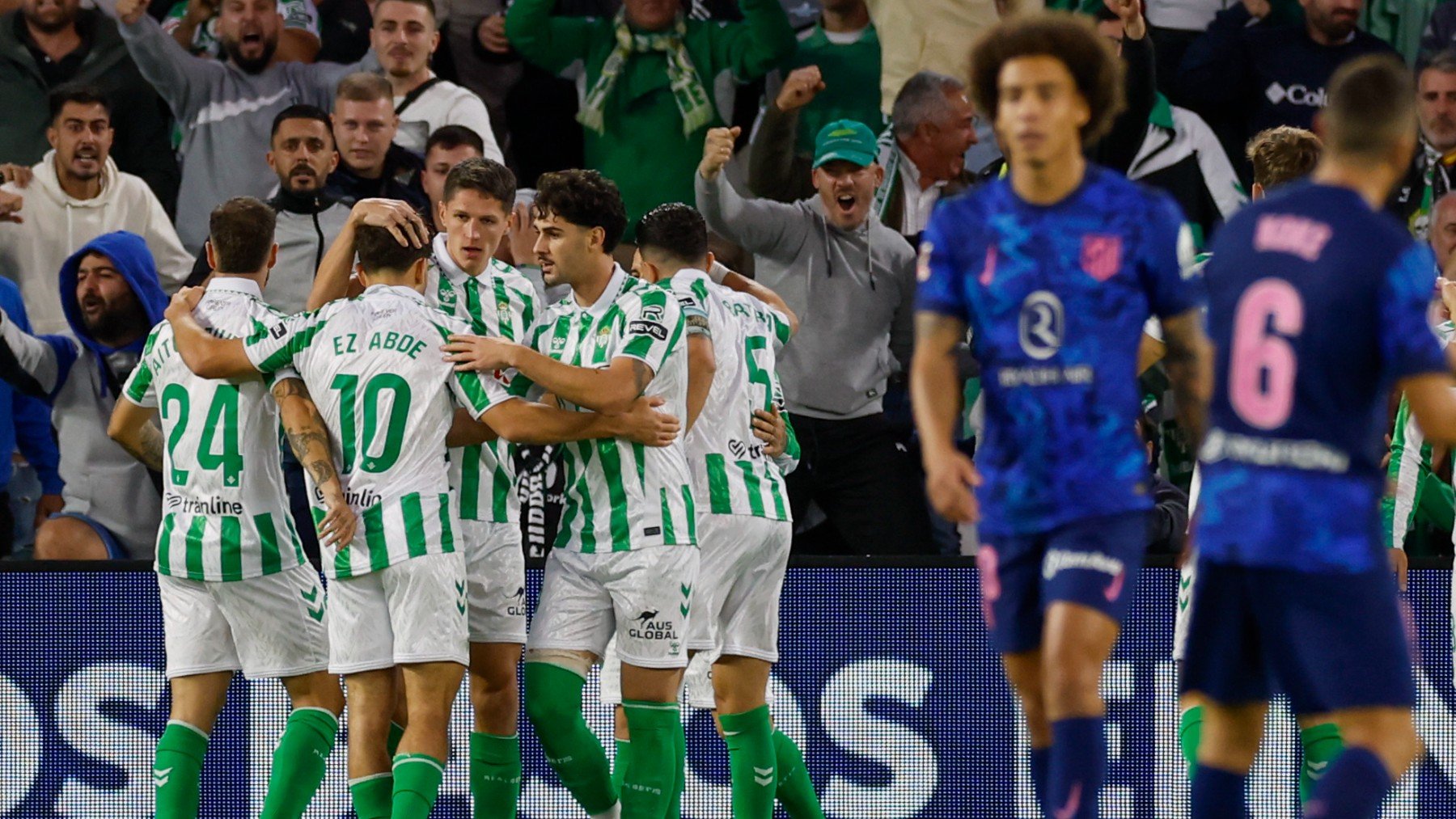 Los jugadores del Betis celebran el gol en propia de Giménez ante la desolación de Witsel y Koke. (EFE).