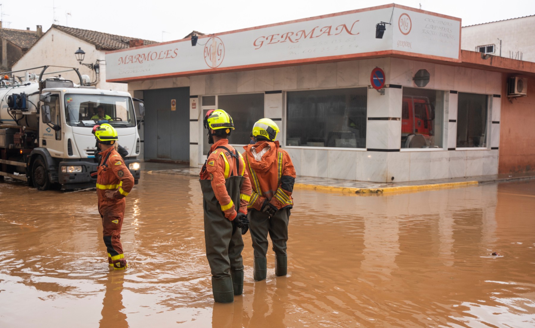 Tres bomberos en una zona inundada de Llombai, en Valencia. (Foto: Ep)