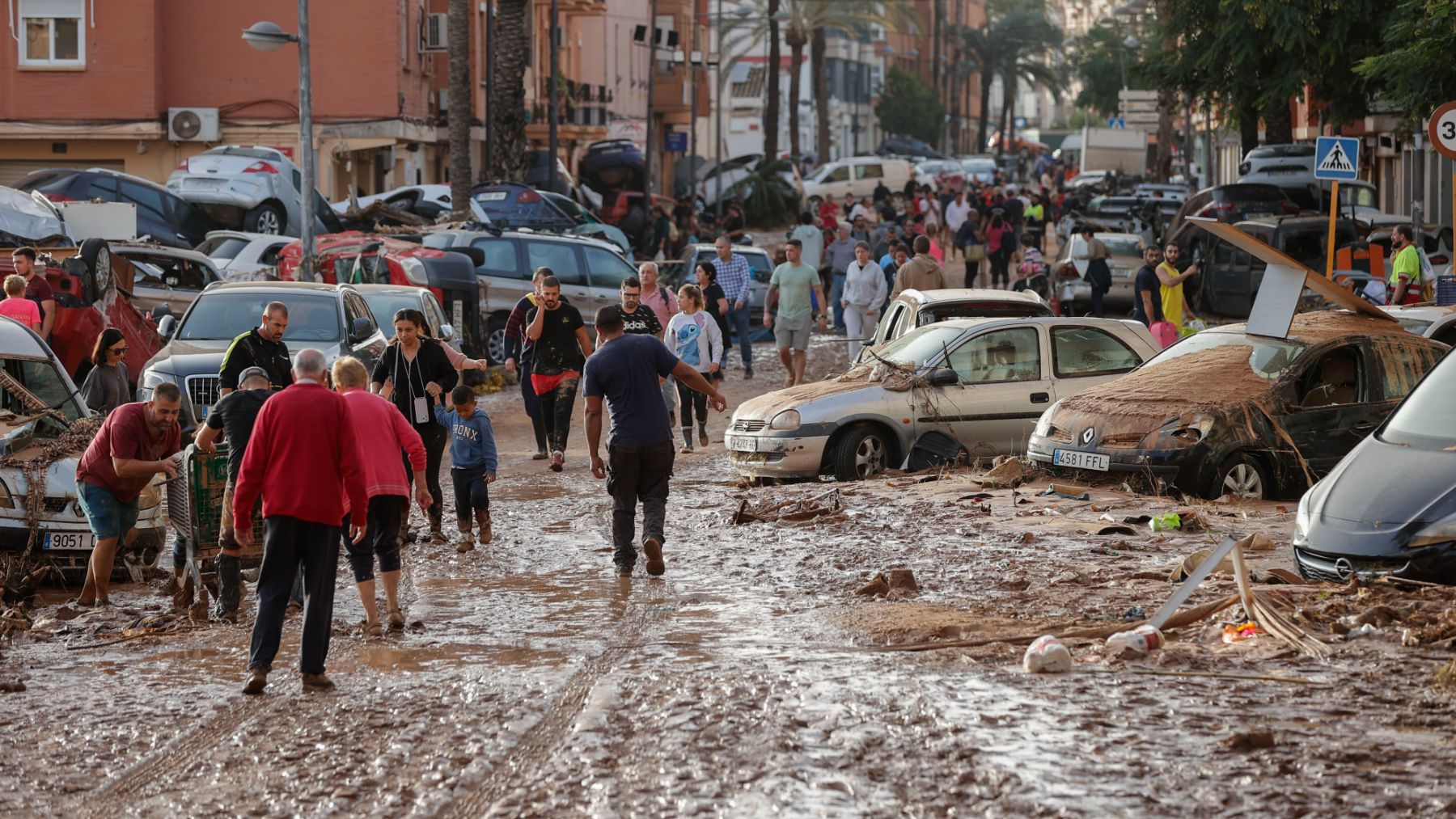 Varias personas caminan por una de las calles afectadas en Paiporta. (EFE)