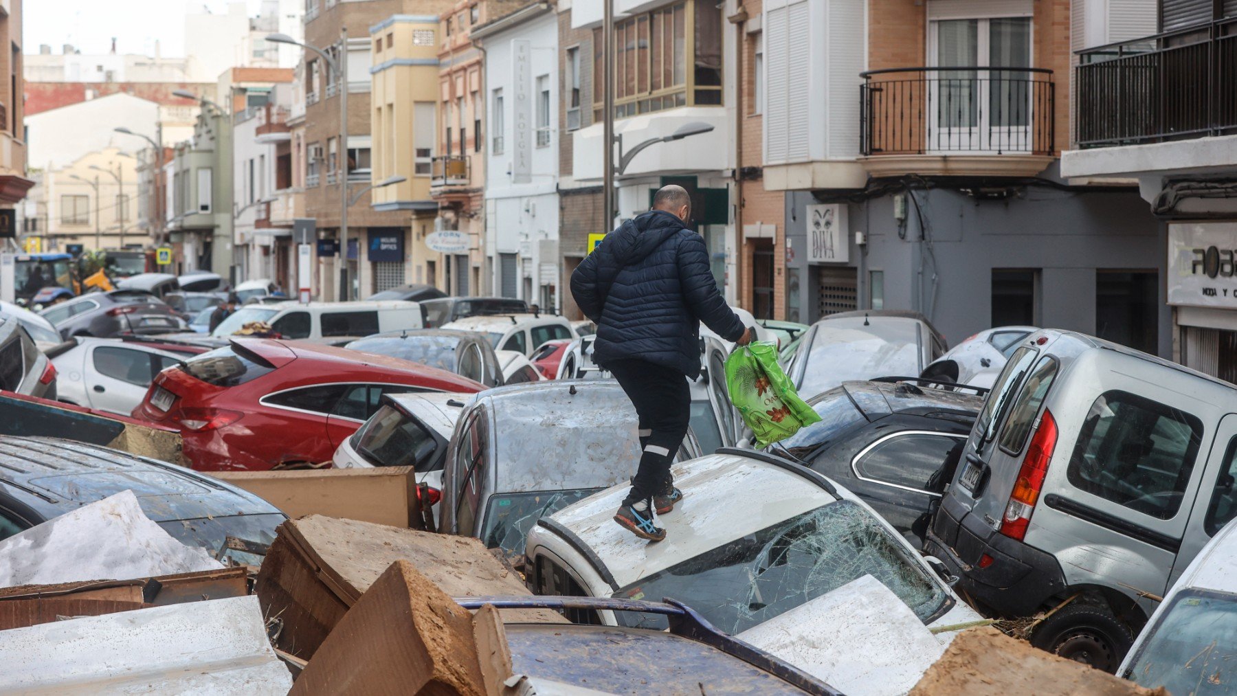 Un hombre camina sobre los coches en Sedaví, Valencia (Foto: Rober Solsona – Europa Press)