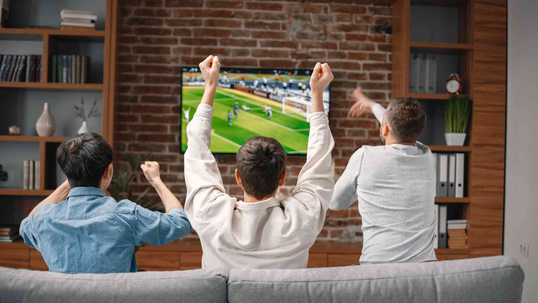 Un grupo de amigos viendo el fútbol en la televisión.