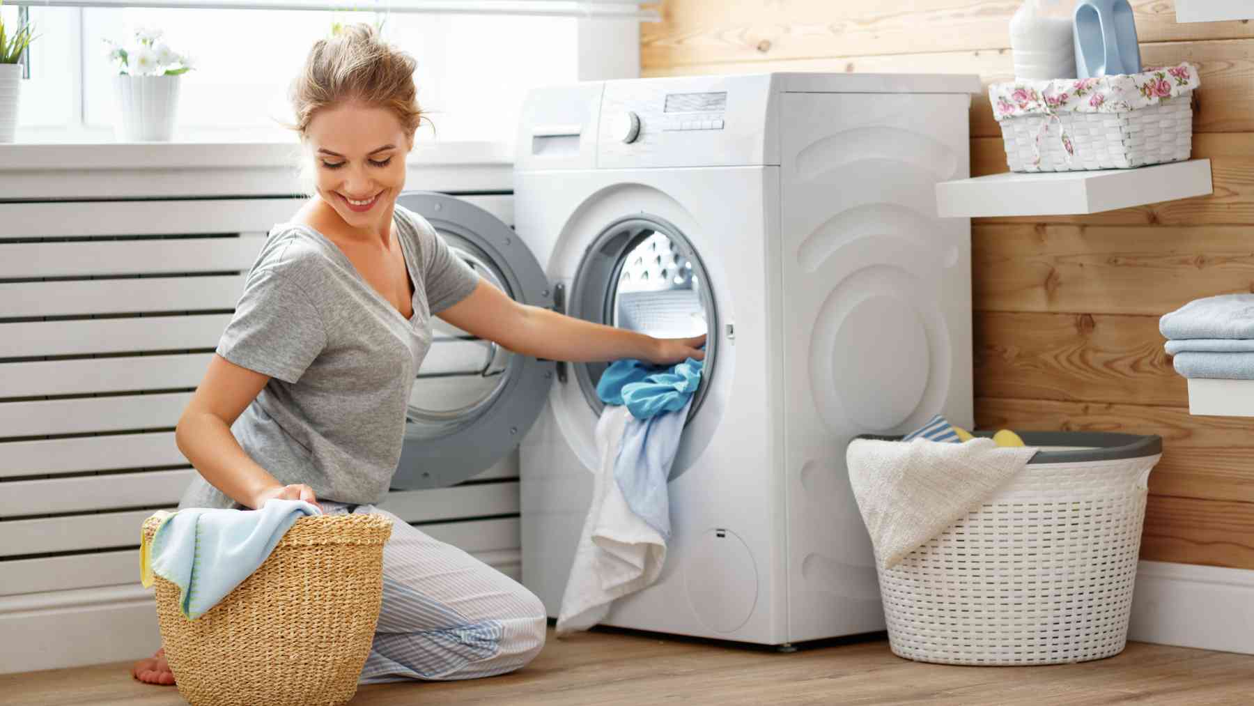 Una mujer poniendo la lavadora.