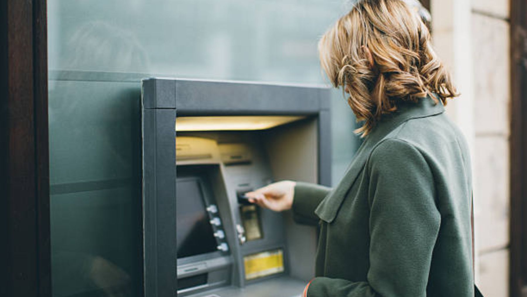 Mujer sacando dinero de un cajero.