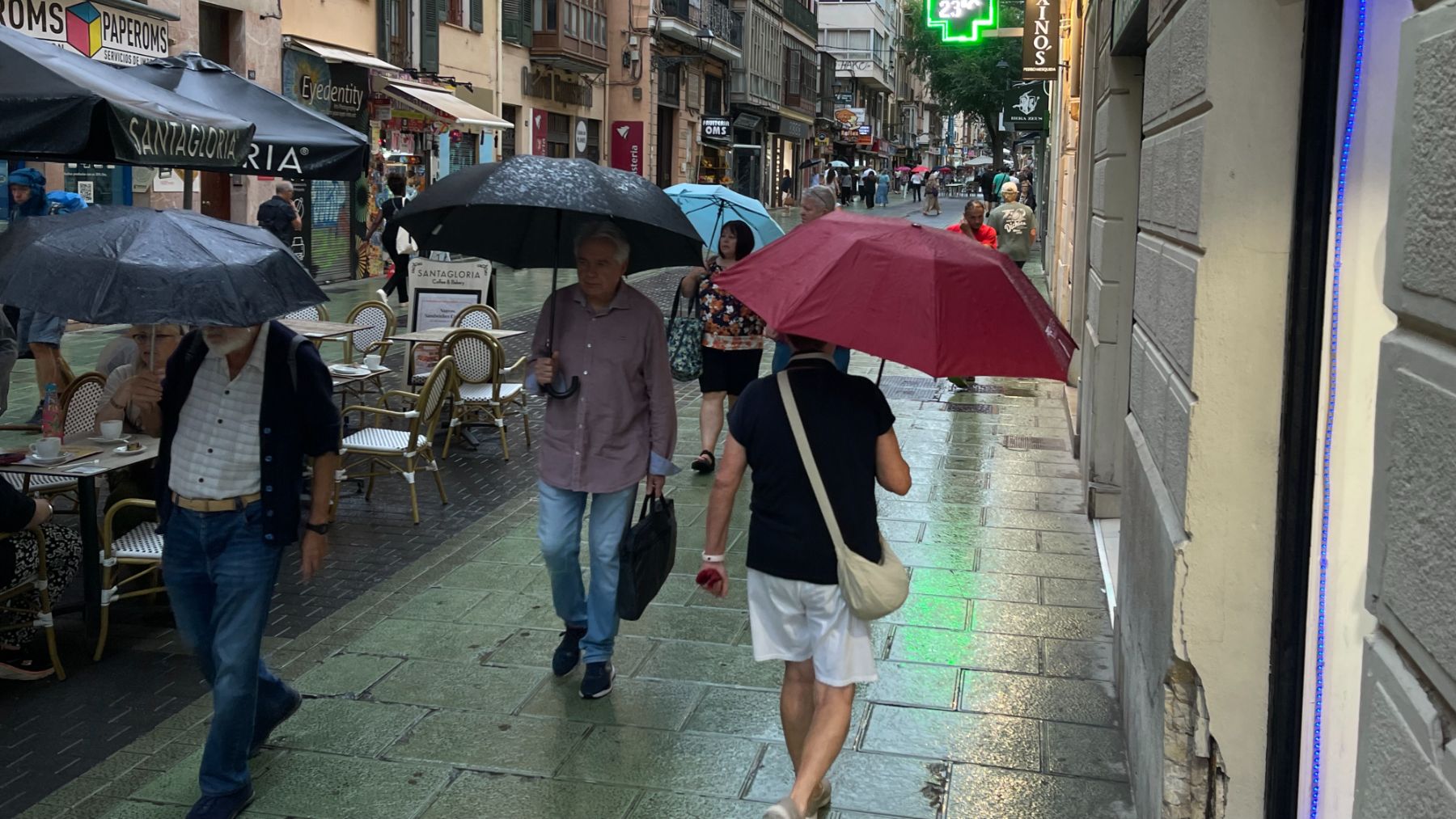 Personas protegiéndose de la lluvia en Palma.