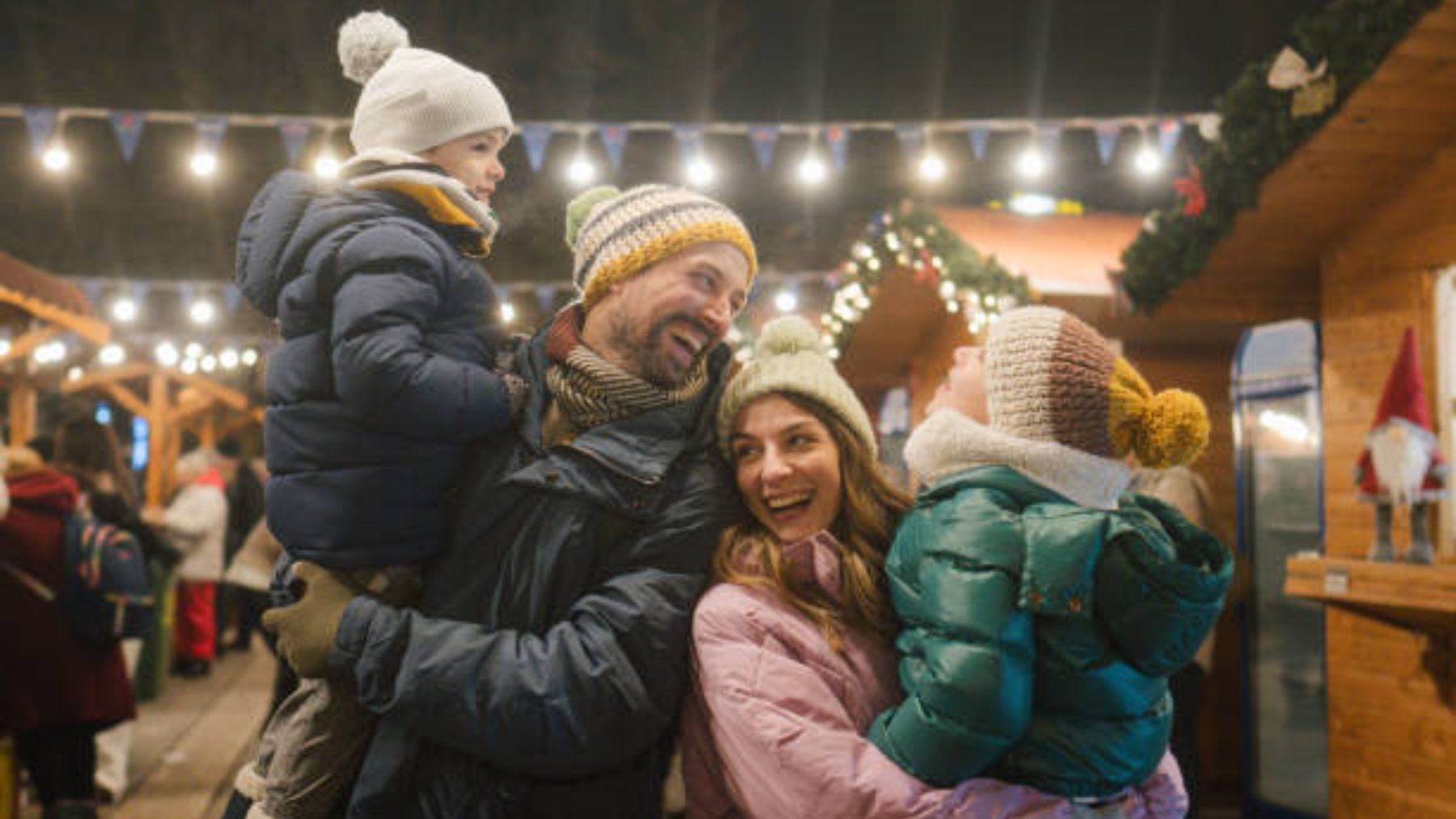 Padres con sus hijos en un mercadillo navideño.