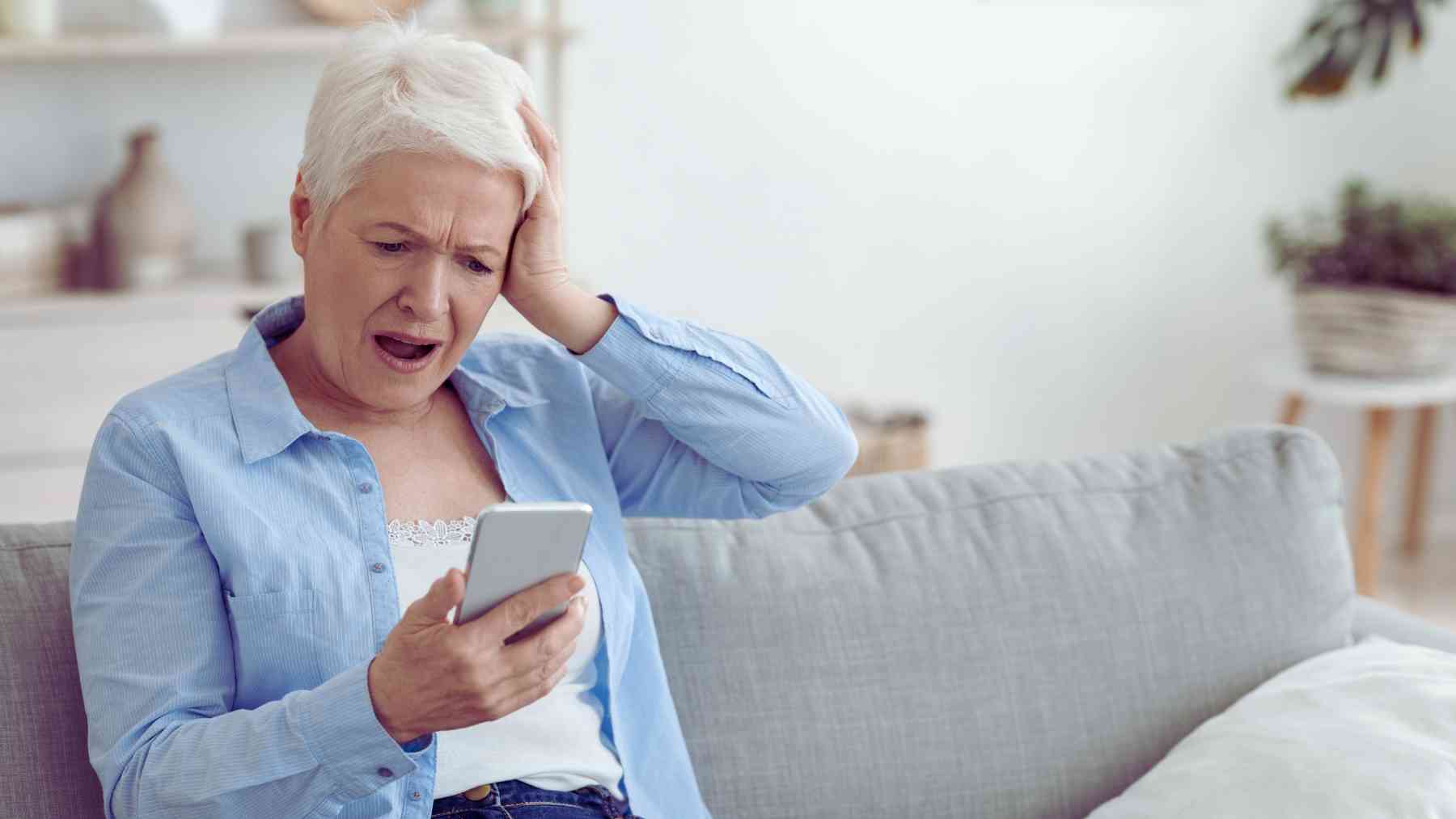 Una mujer mirando el teléfono sorprendida.