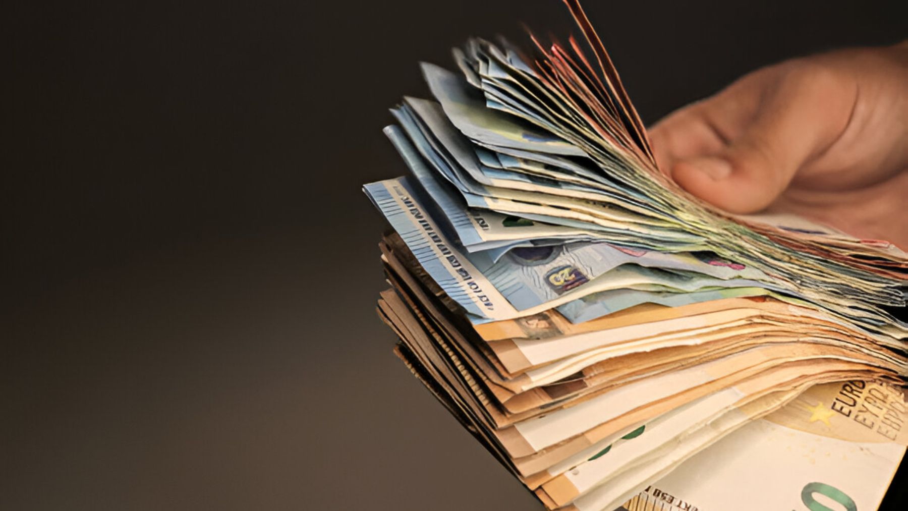 Mano sujetando billetes.