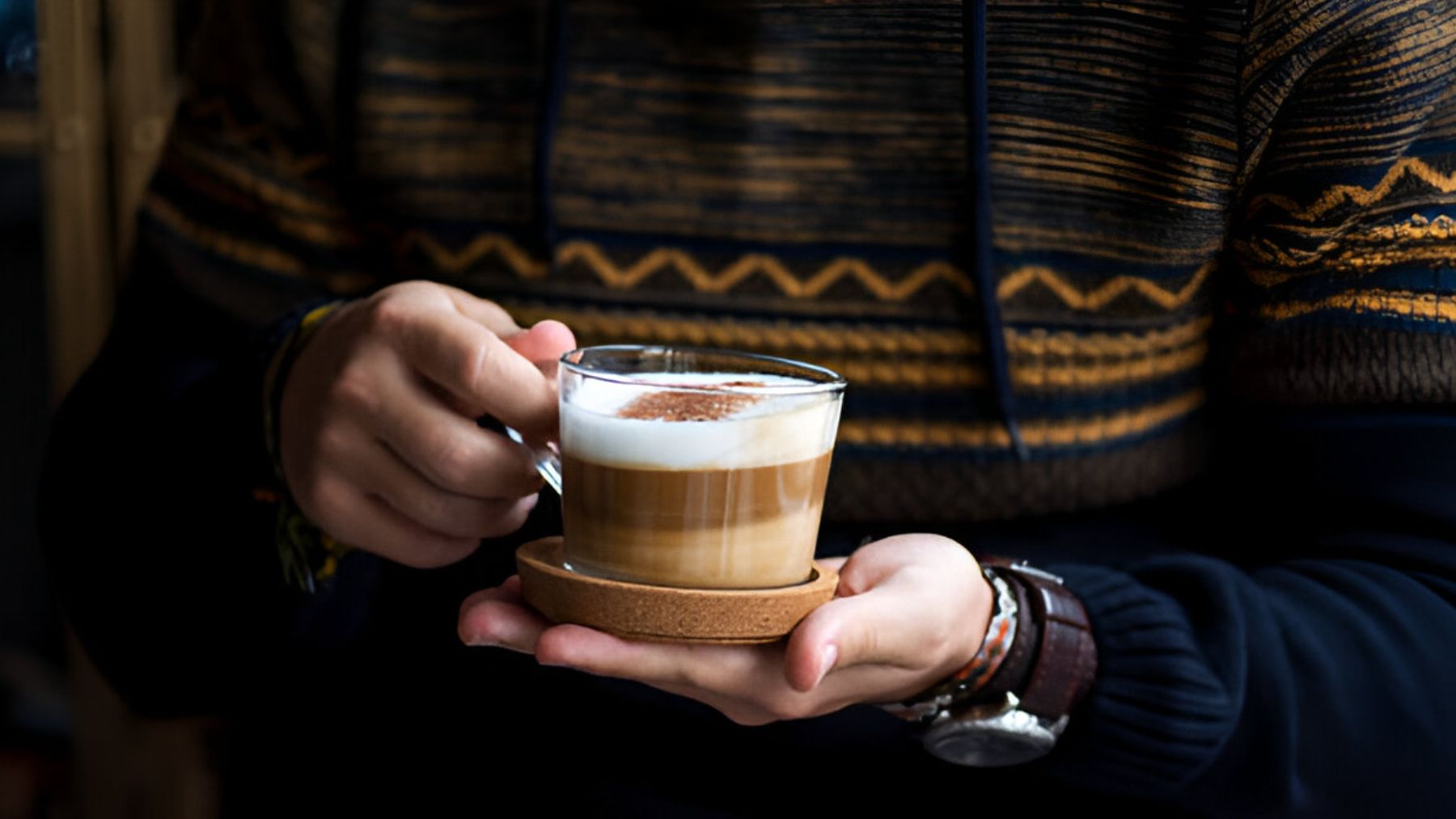 Hombre con taza de café con espuma.