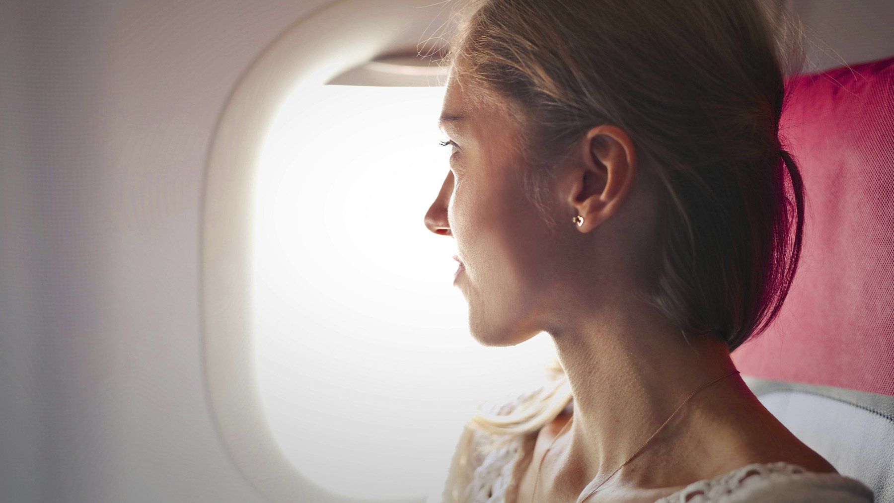 Mujer viajando en avión. Foto: Pexels.