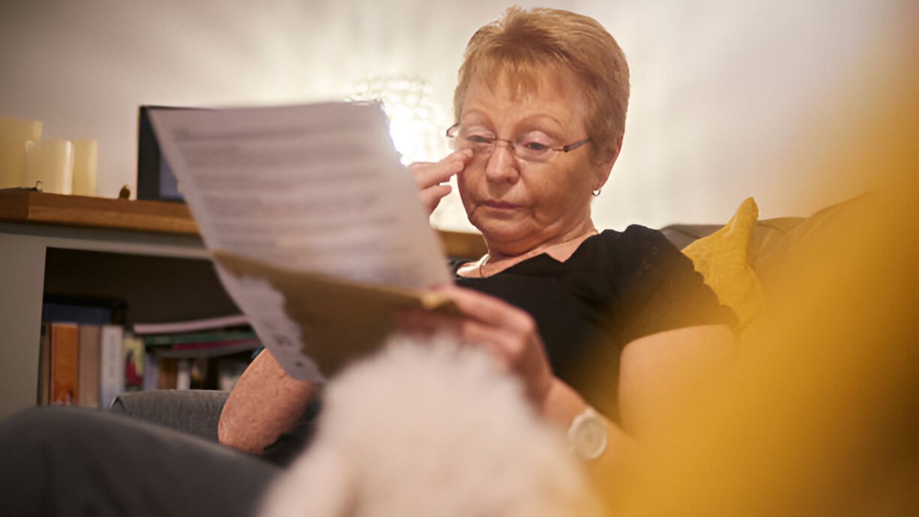 Mujer mayor leyendo una carta.