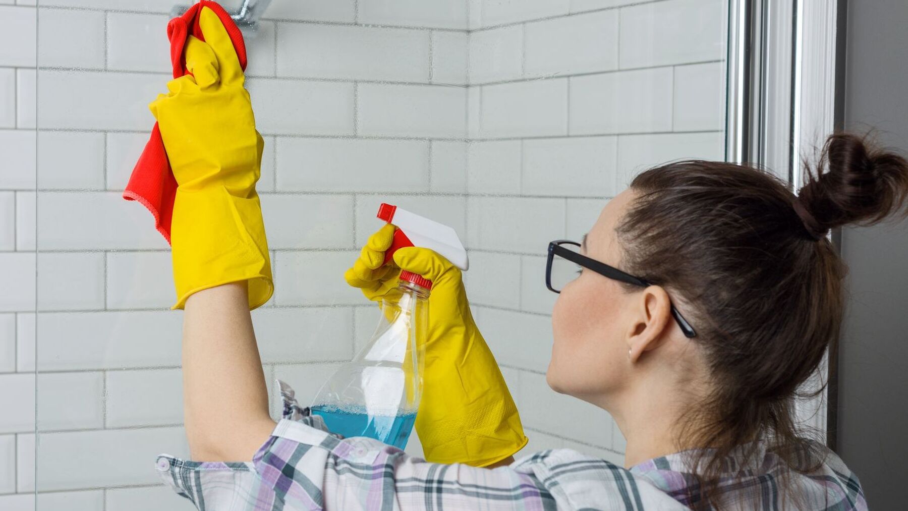 House cleaning. Woman cleaning the bathroom, female in casual clothes with detergent and washcloth at home in the bathroom