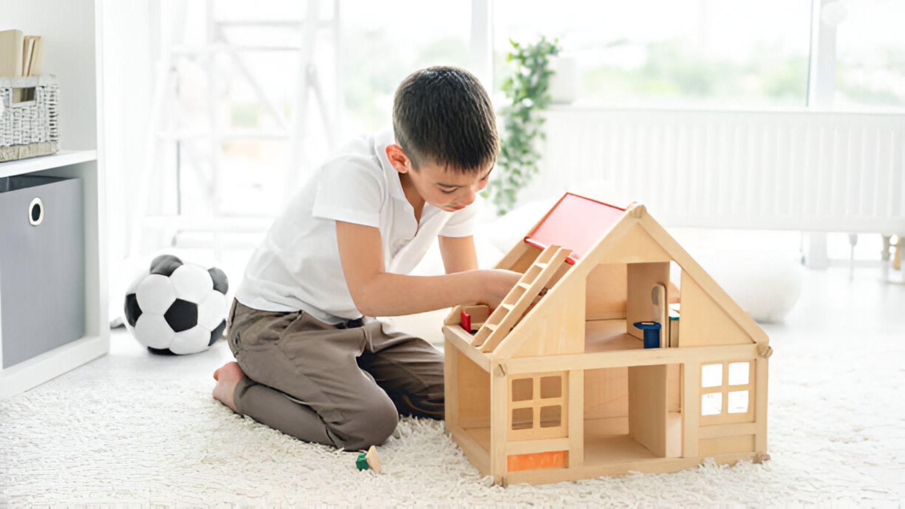 Un niño jugando con casita de madera.