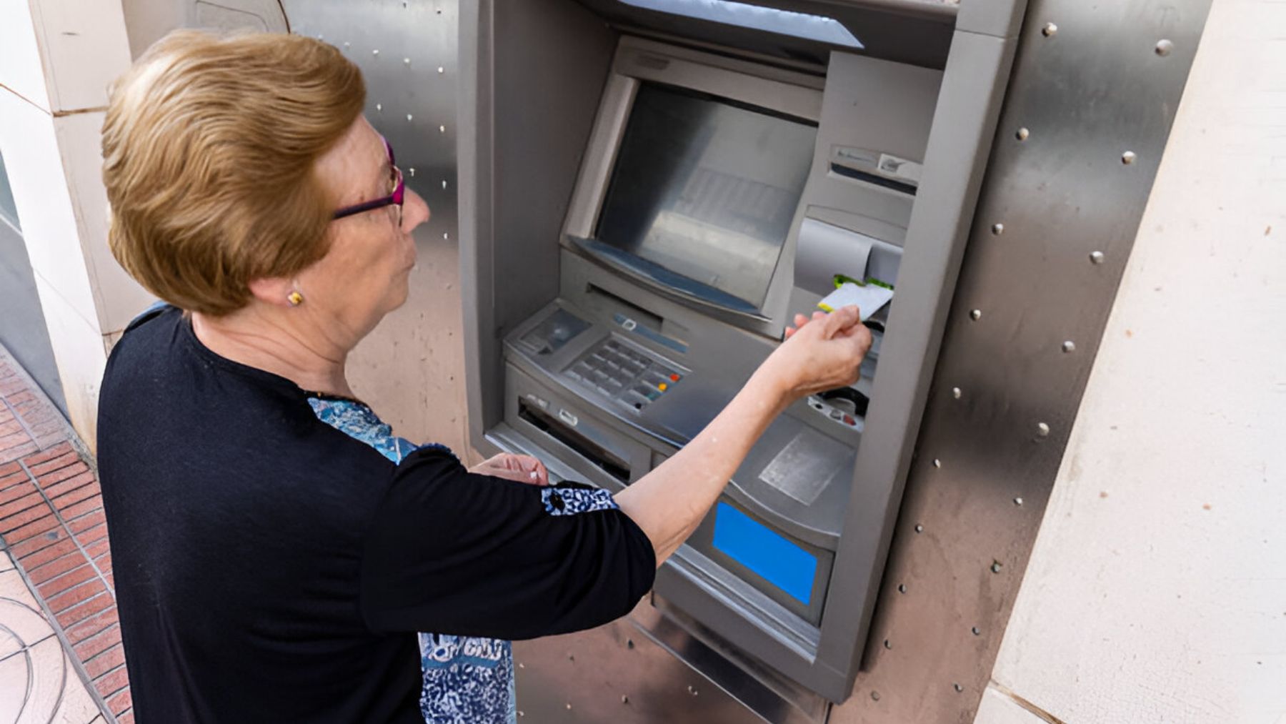 Mujer sacando dinero de un cajero.