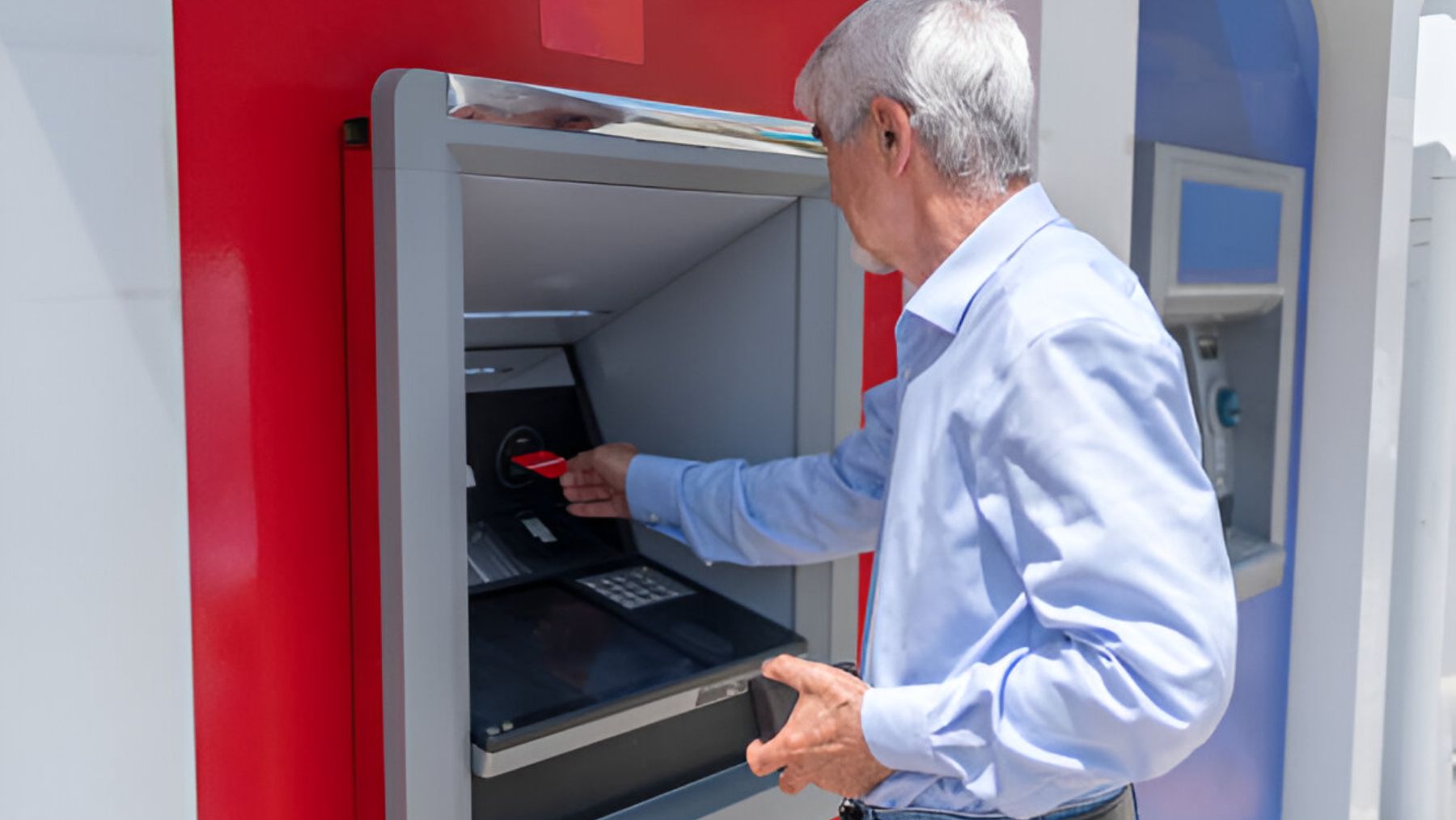 Hombre mayor sacando dinero de un cajero.