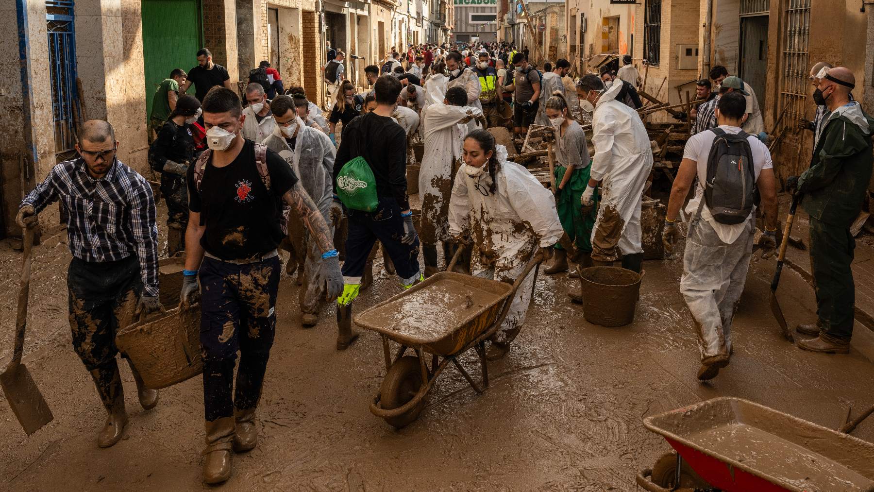 Una calle donde los voluntarios usan mascarilla.